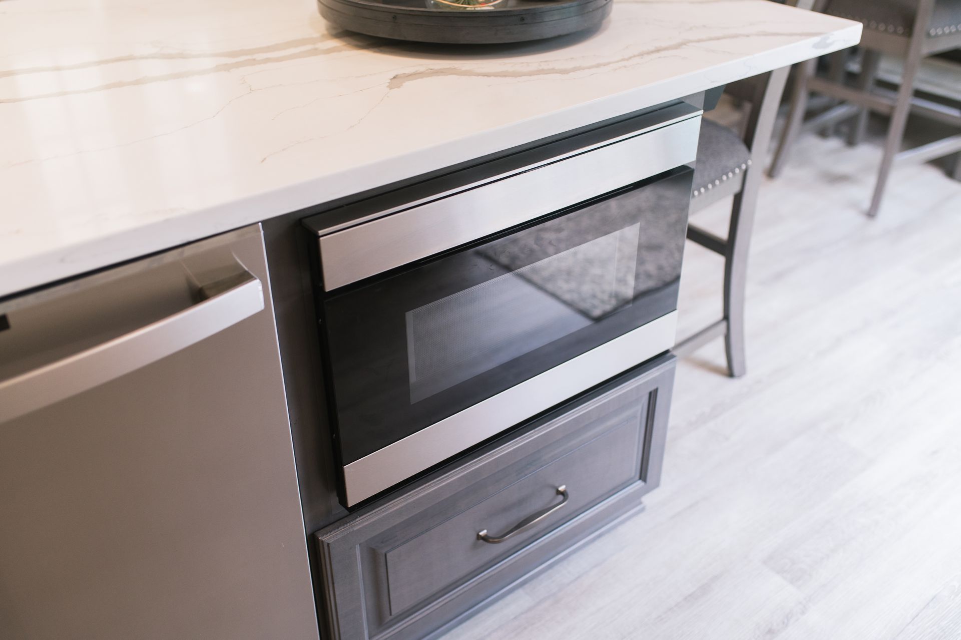 A microwave oven is built into a cabinet in a kitchen.