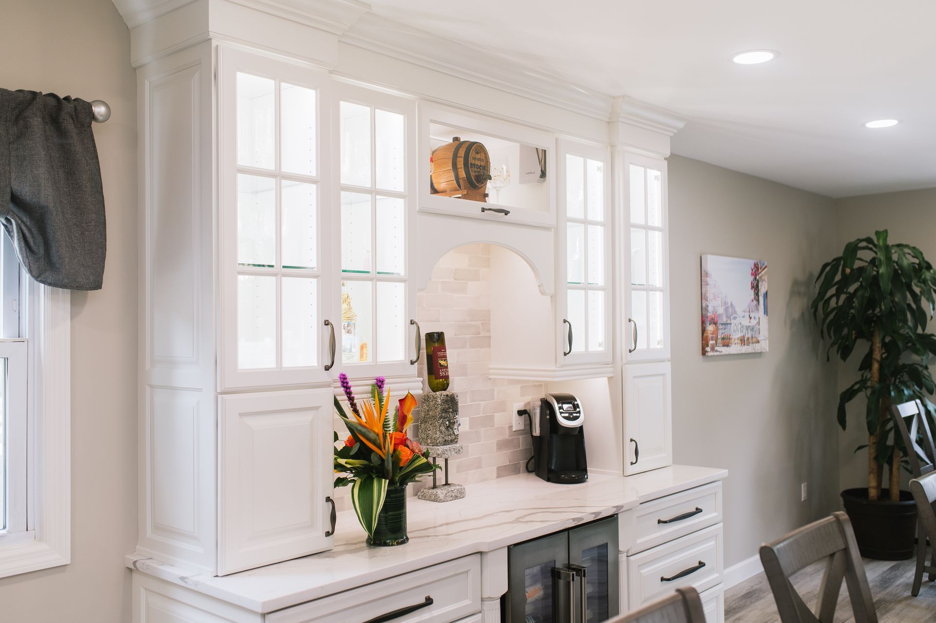 A kitchen with white cabinets and a coffee maker on the counter.