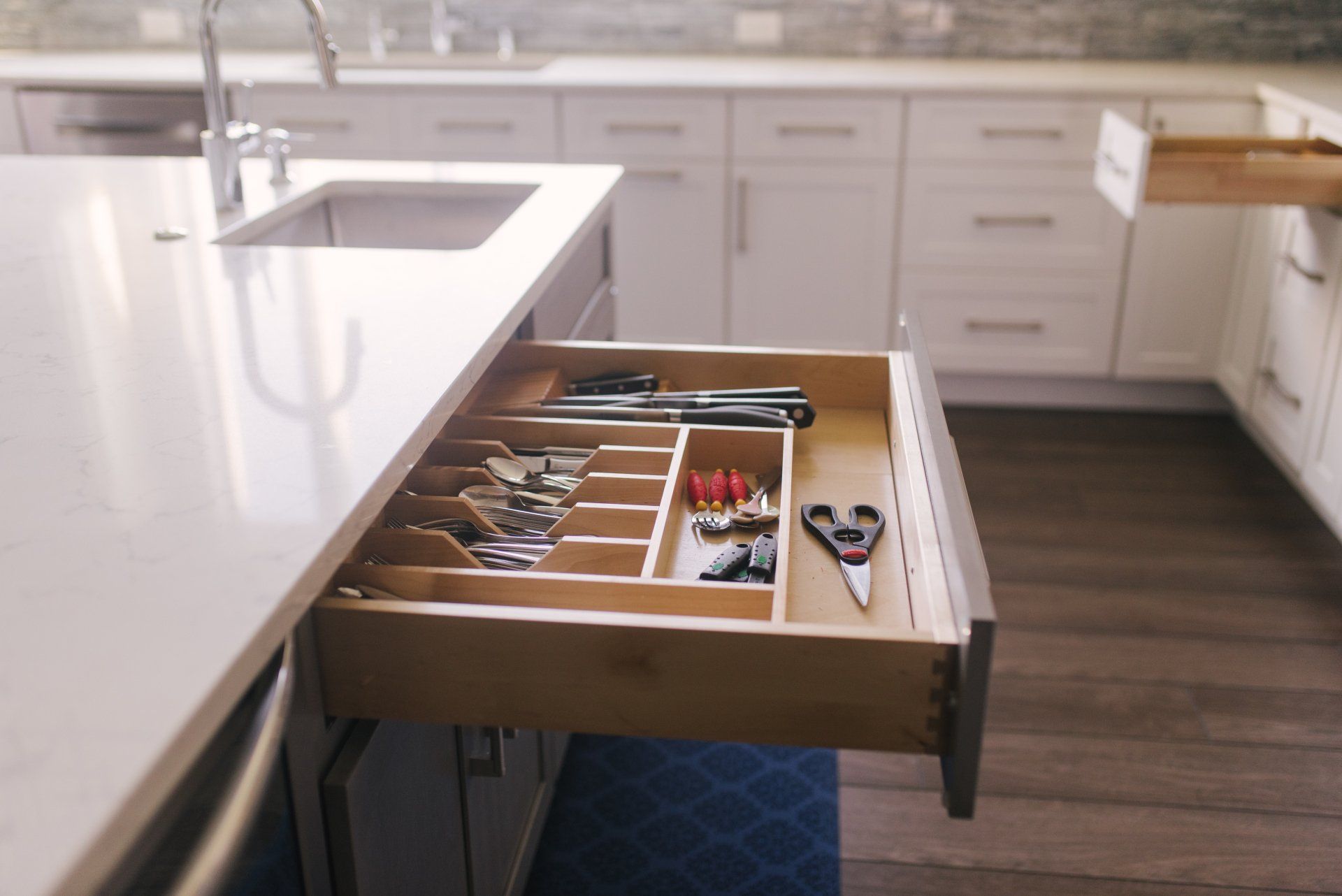 A kitchen drawer filled with knives and scissors