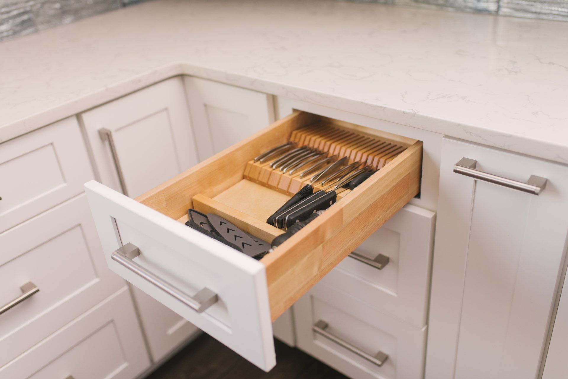 A kitchen drawer filled with knives and forks.