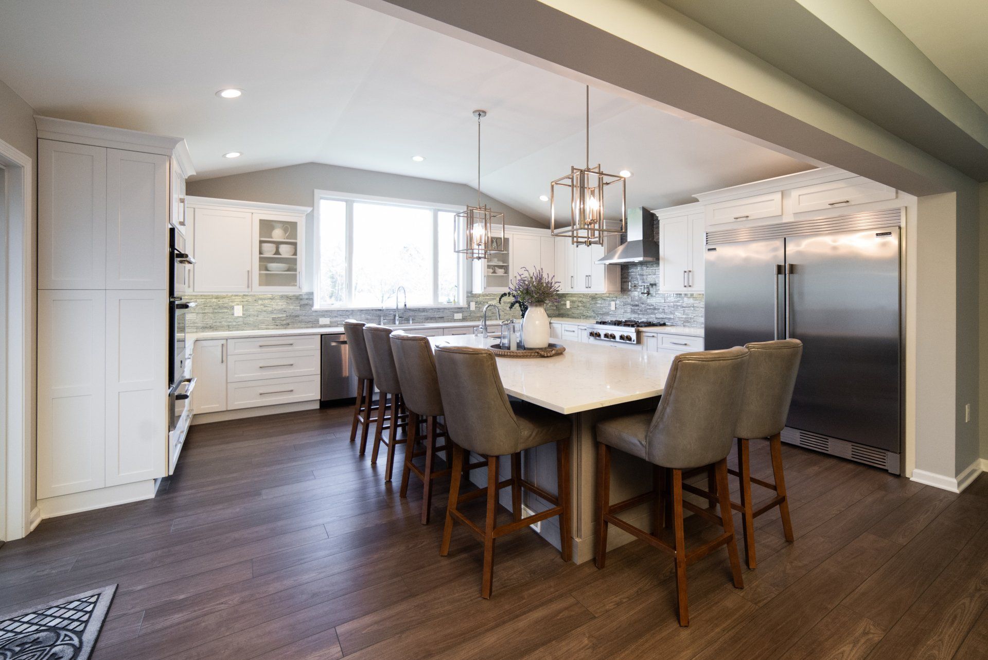A kitchen with a large island and a lot of chairs