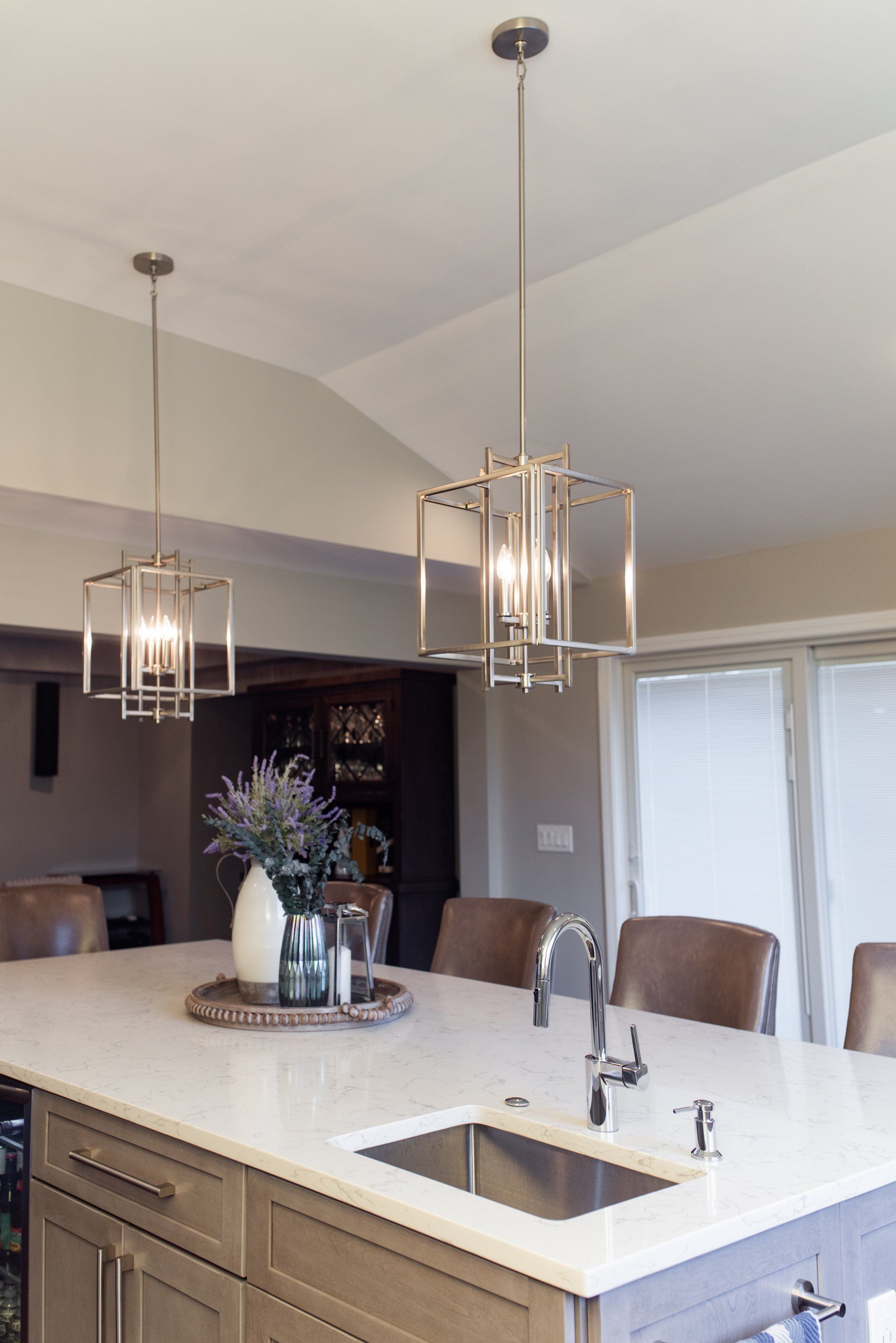 A kitchen with a sink and a table with a vase of flowers on it.