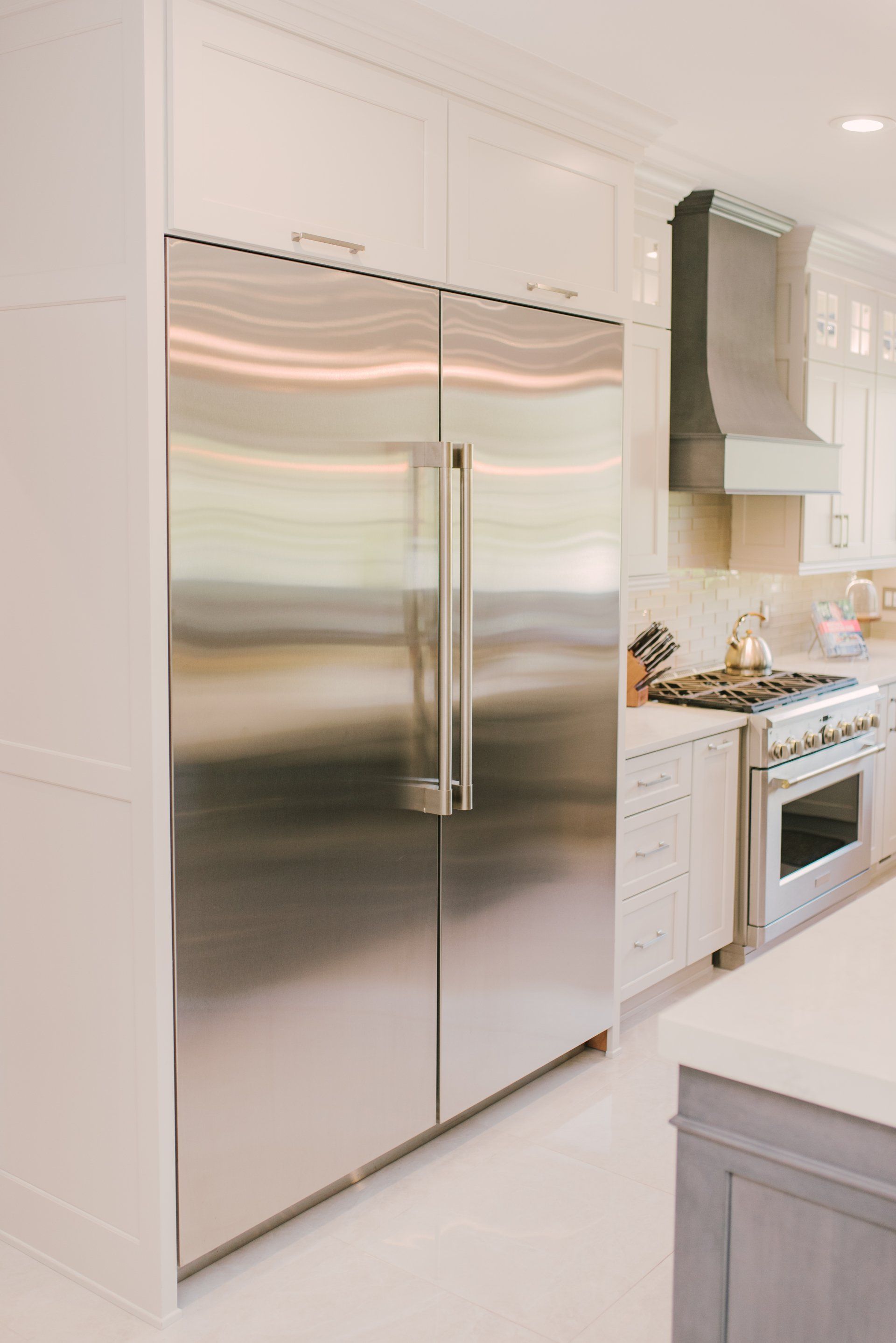 A kitchen with stainless steel appliances and white cabinets.