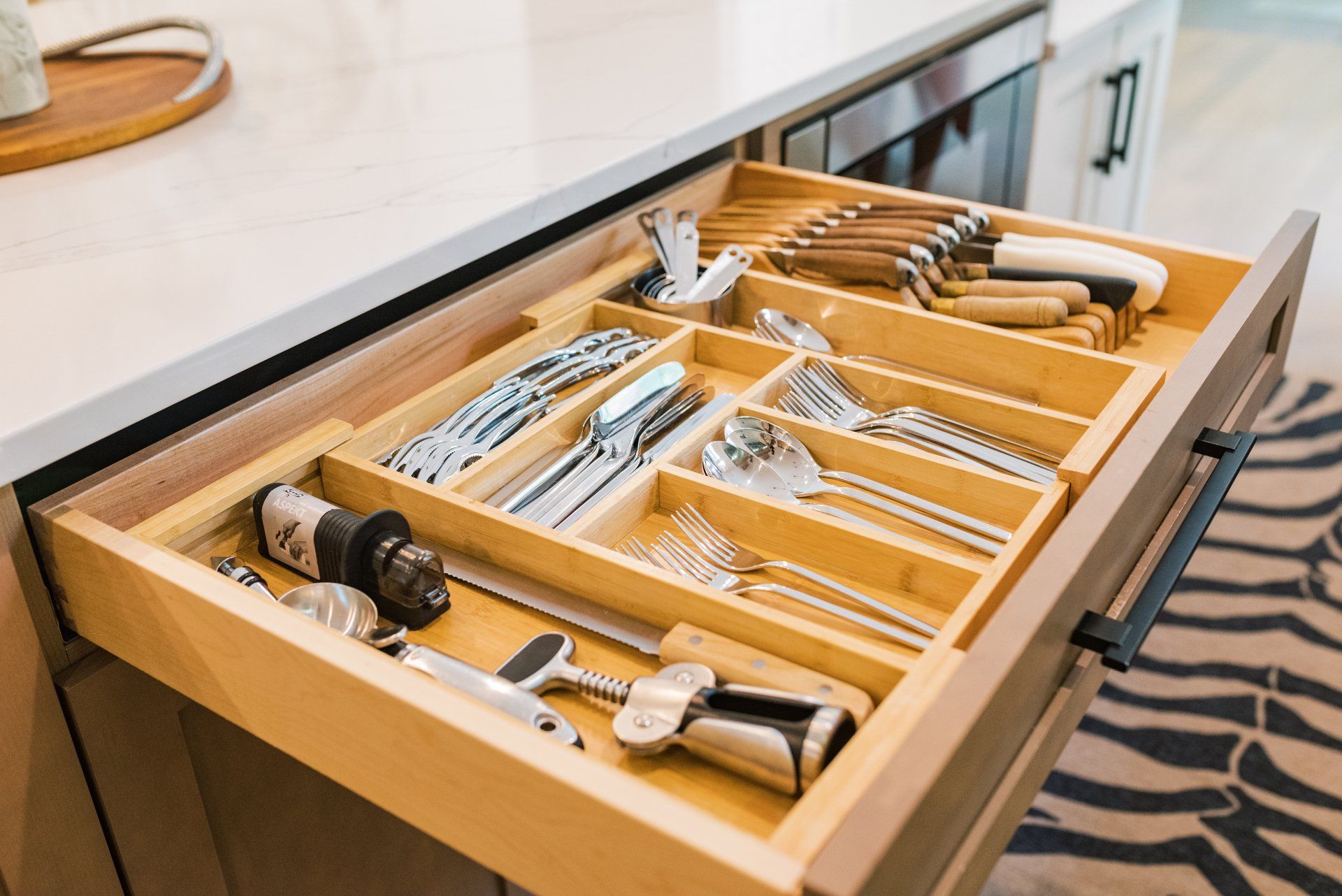 A kitchen drawer filled with silverware and knives.
