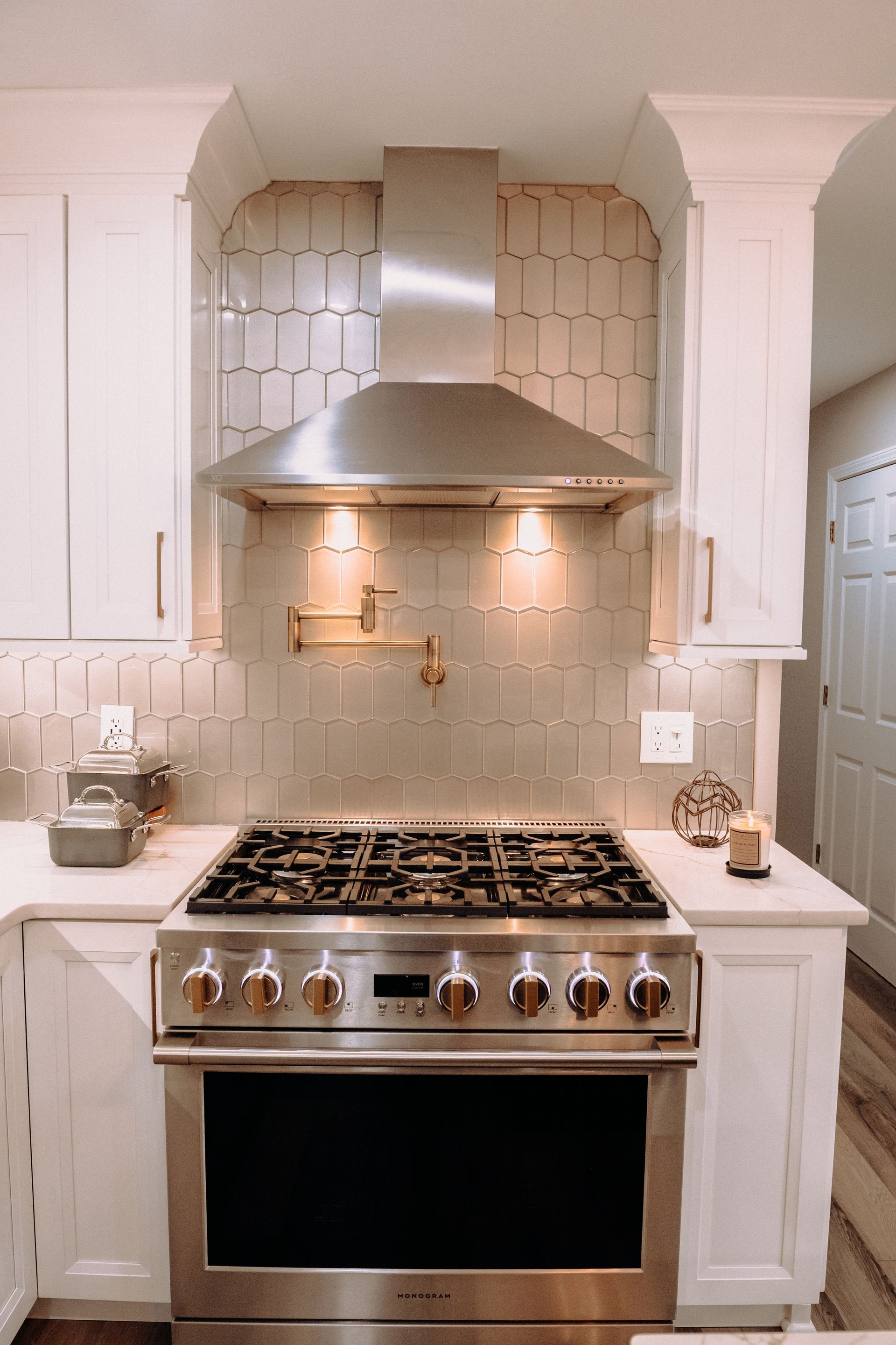 A stainless steel stove and oven in a kitchen with white cabinets.