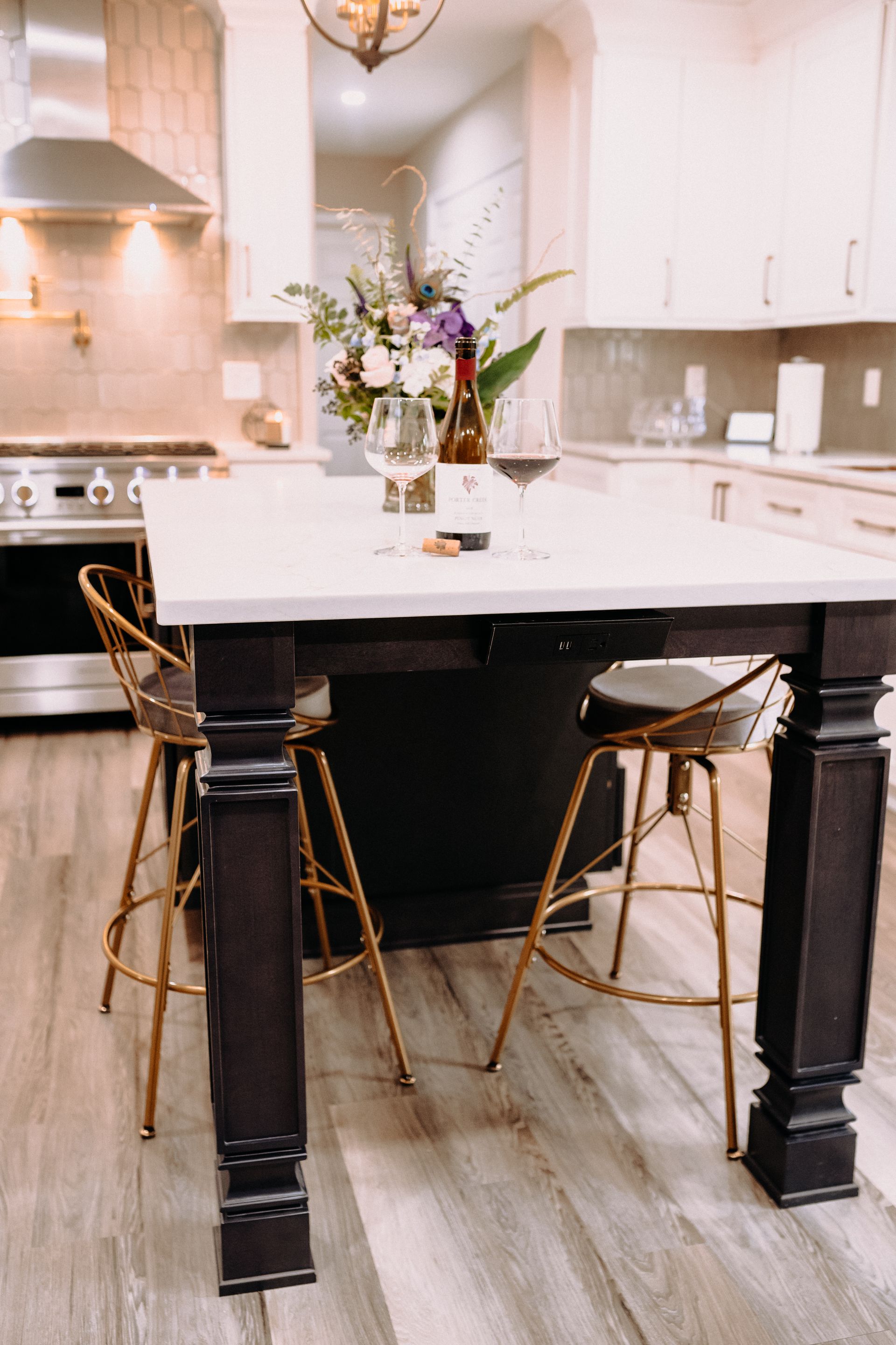 A kitchen with a table and chairs and a bottle of wine on it.