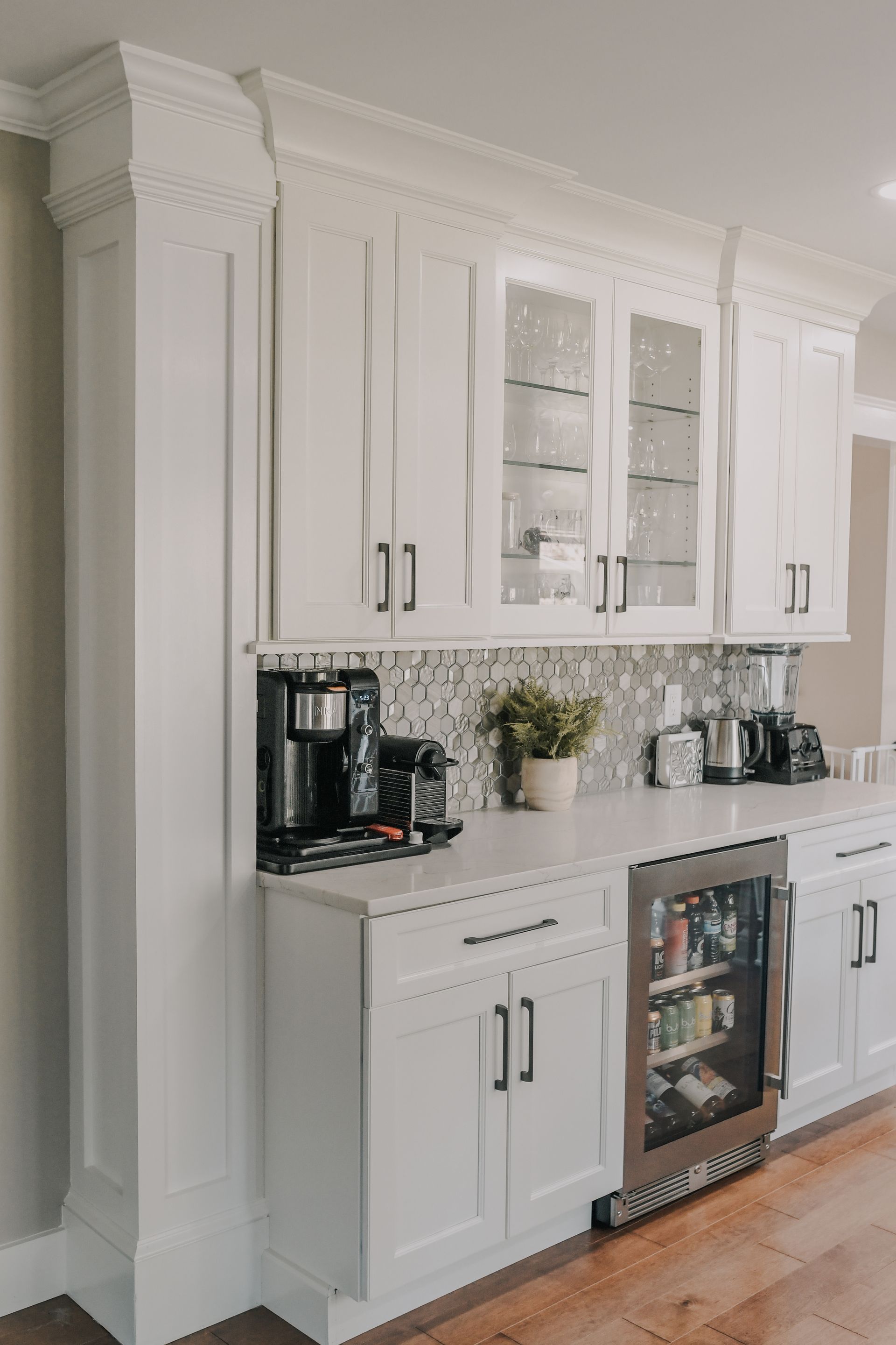 A kitchen with white cabinets and a stainless steel refrigerator