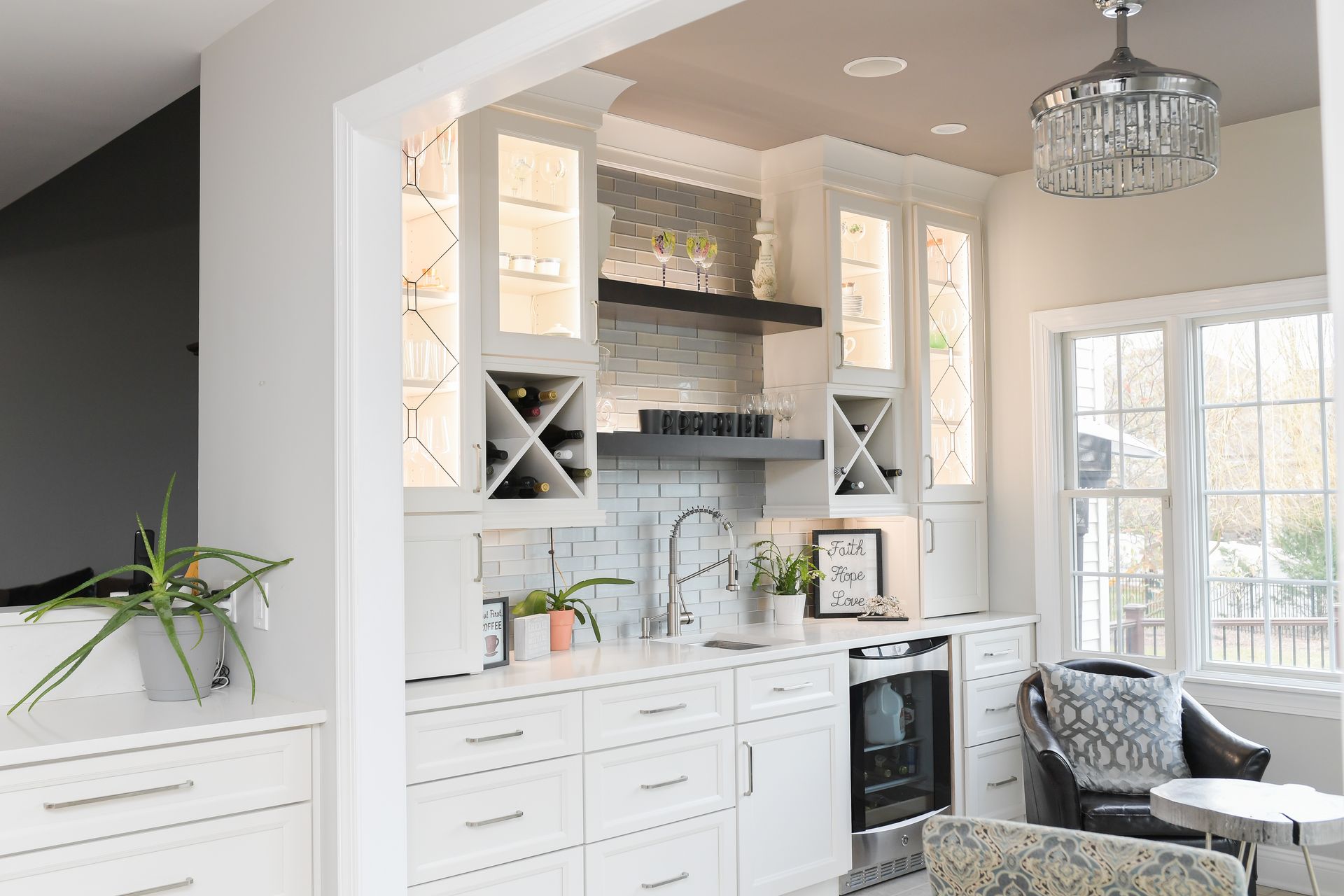 A kitchen with white cabinets and a wine rack on the wall.