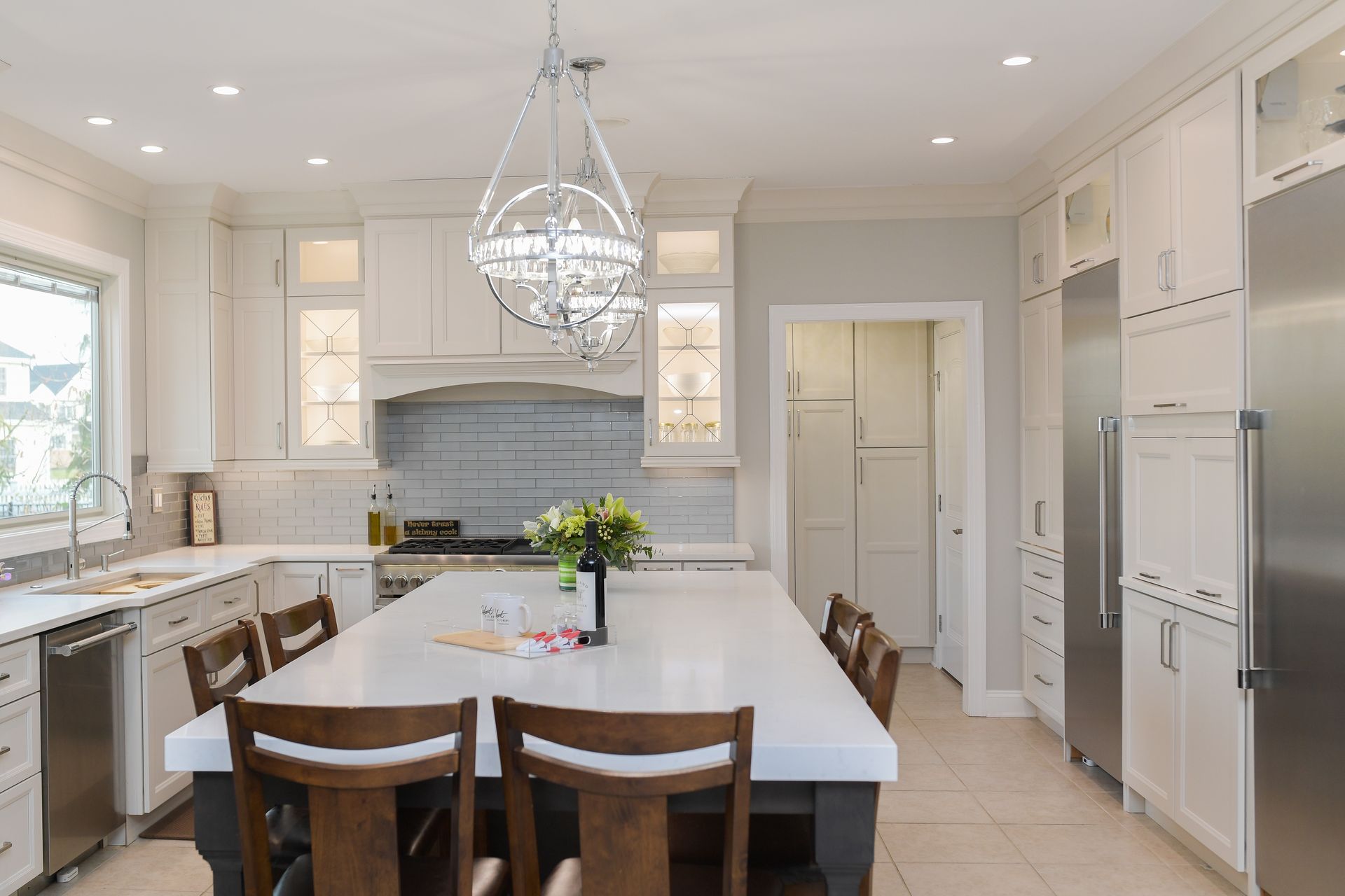 A kitchen with white cabinets and stainless steel appliances and a large island.