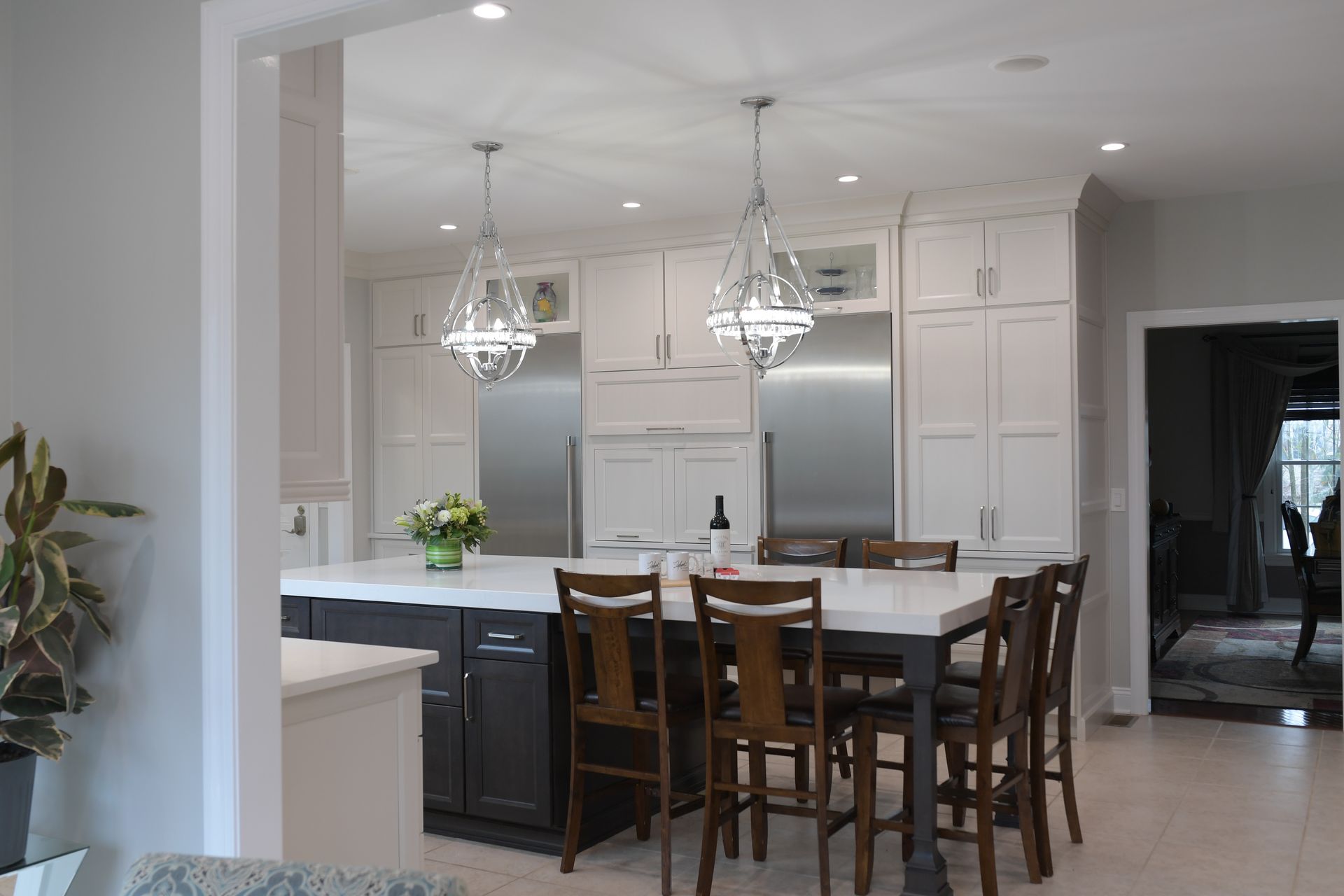 A kitchen with a dining table and chairs and stainless steel appliances.