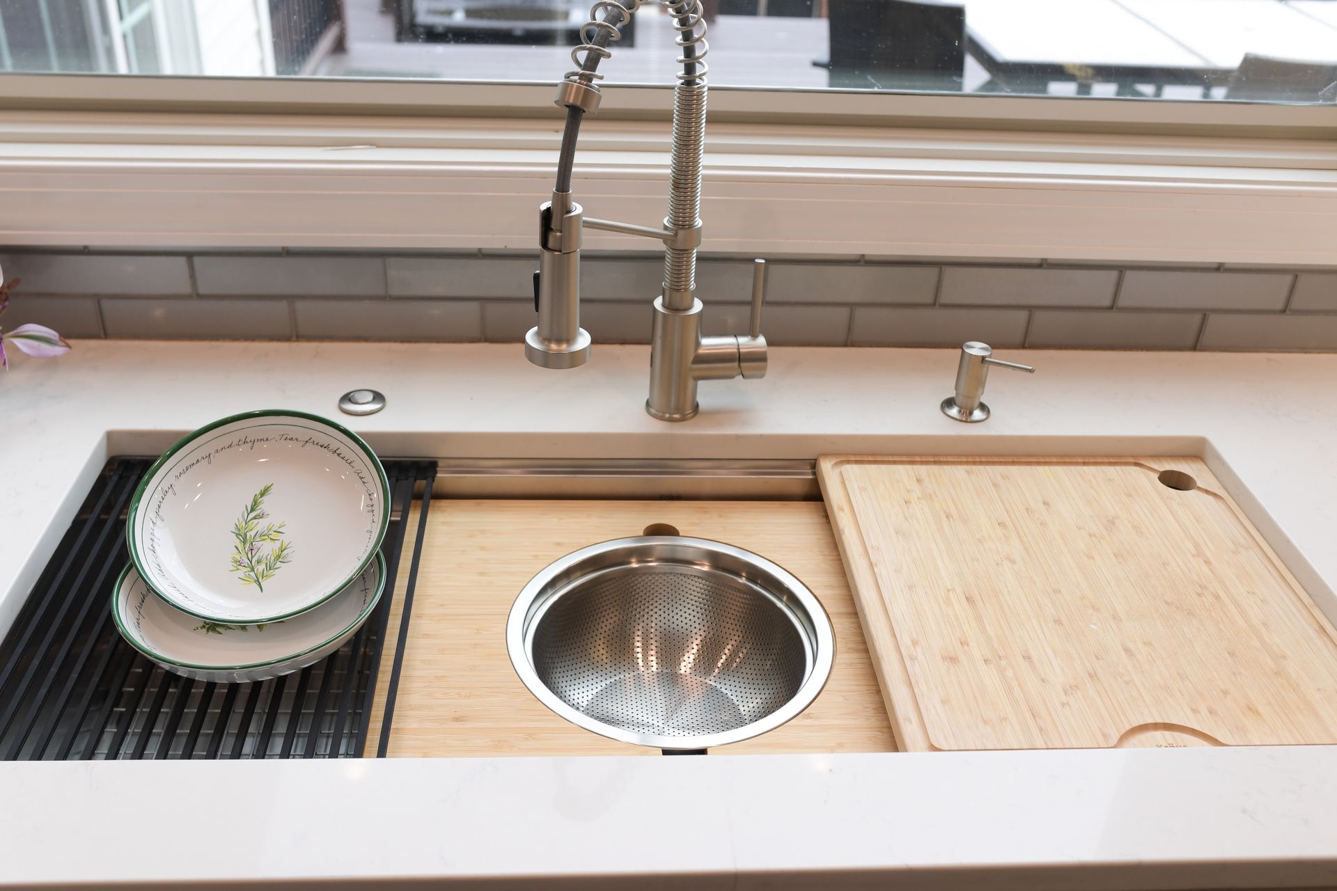 A kitchen sink with a cutting board underneath it