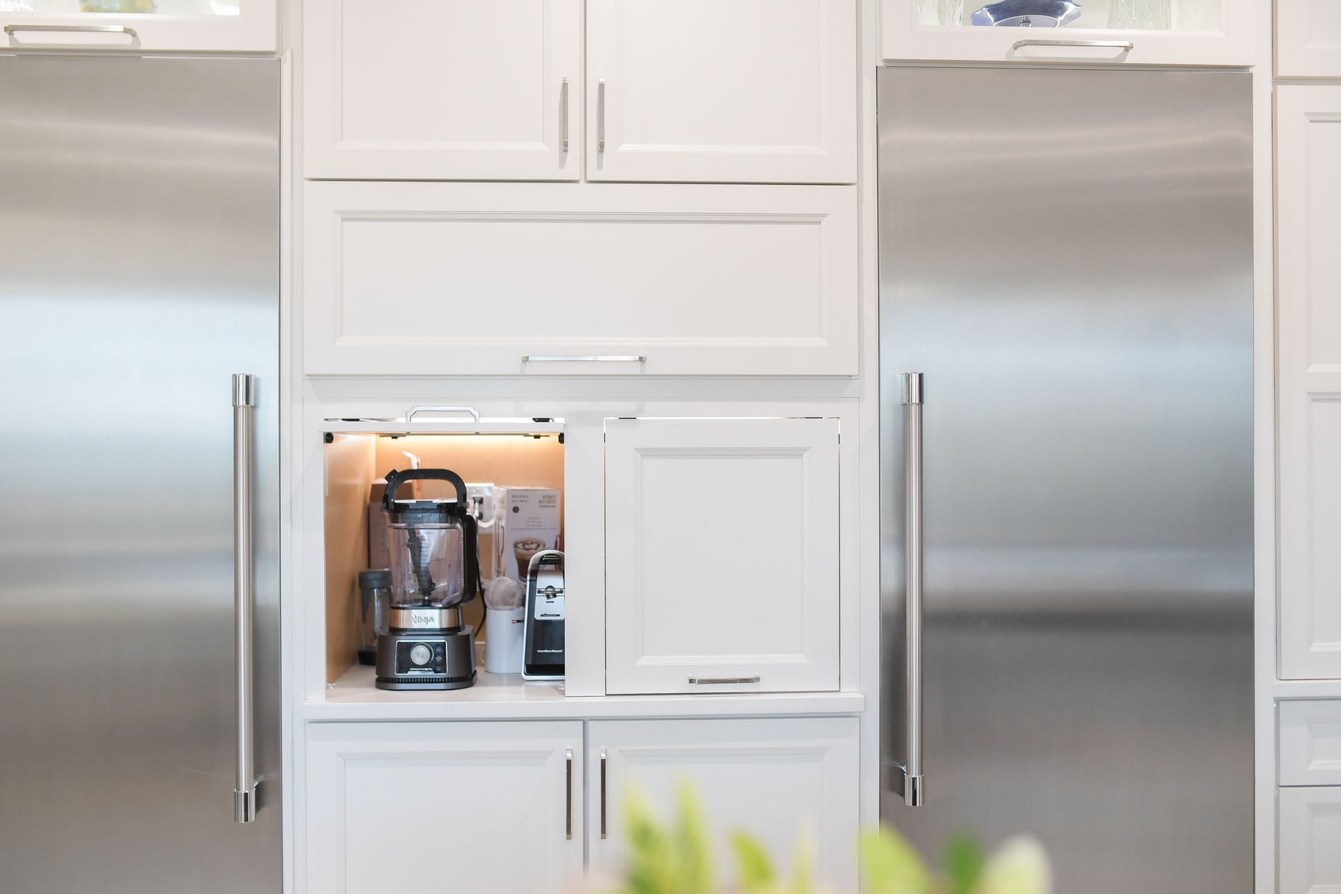 A kitchen with stainless steel appliances and white cabinets.