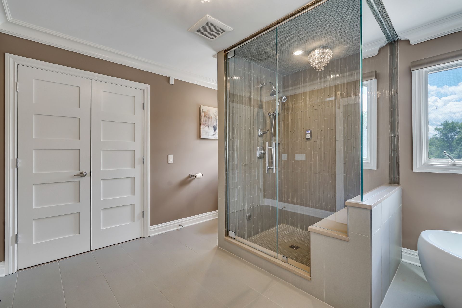 A bathroom with a walk in shower and a tub