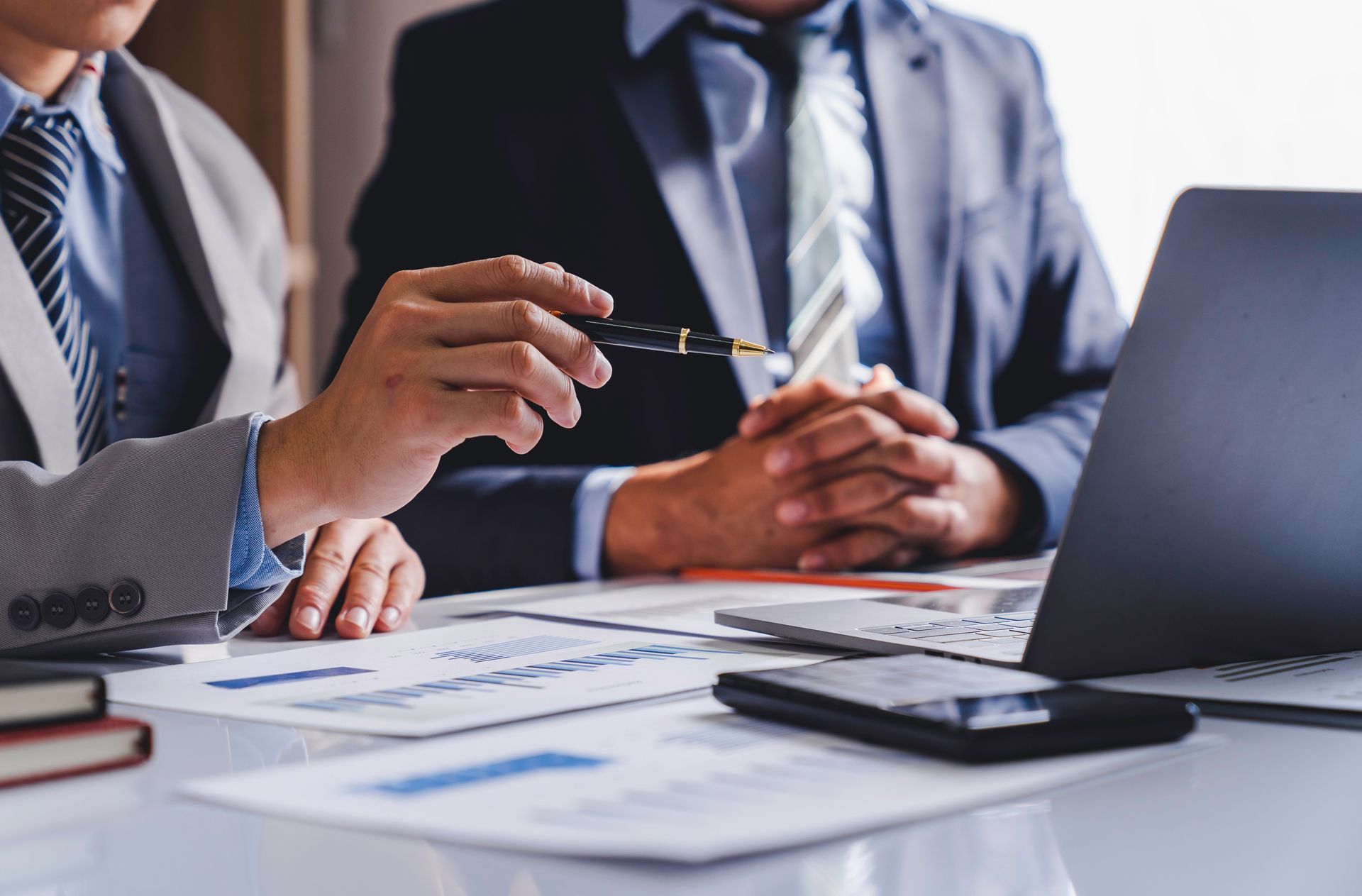 Two Businessmen Are Sitting at a Table Looking at a Laptop Computer