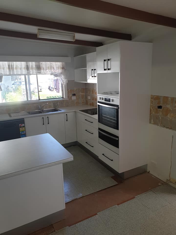 A Kitchen With White Cabinets , a Sink , and an Oven — Pacific Cabinets In Grafton, NSW