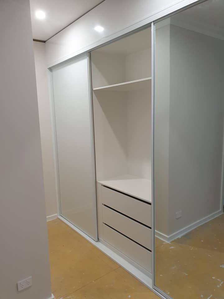 A Walk in Closet With Sliding Glass Doors and Drawers — Pacific Cabinets In Evans Head, NSW