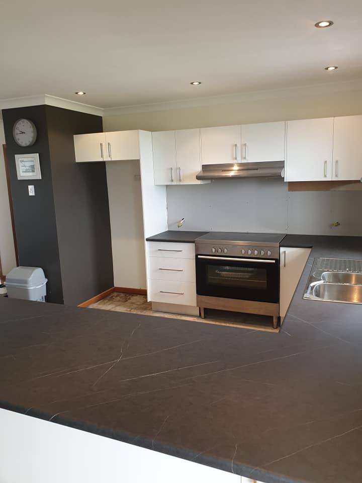 A Kitchen With Stainless Steel Appliances and White Cabinets — Pacific Cabinets In Yamba, NSW