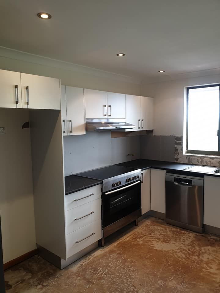 A Kitchen With Stainless Steel Appliances and White Cabinets — Pacific Cabinets In Yamba, NSW