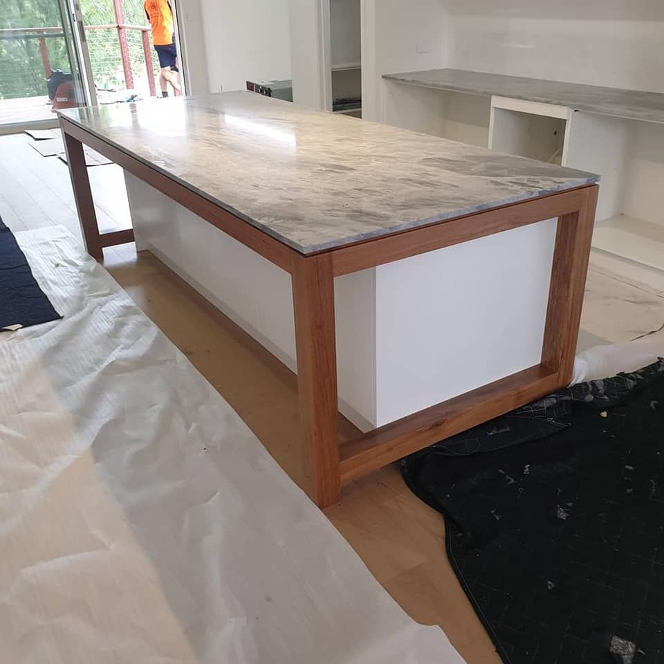 A Long Table With a Marble Top and Wooden Frame — Pacific Cabinets In Yamba, NSW