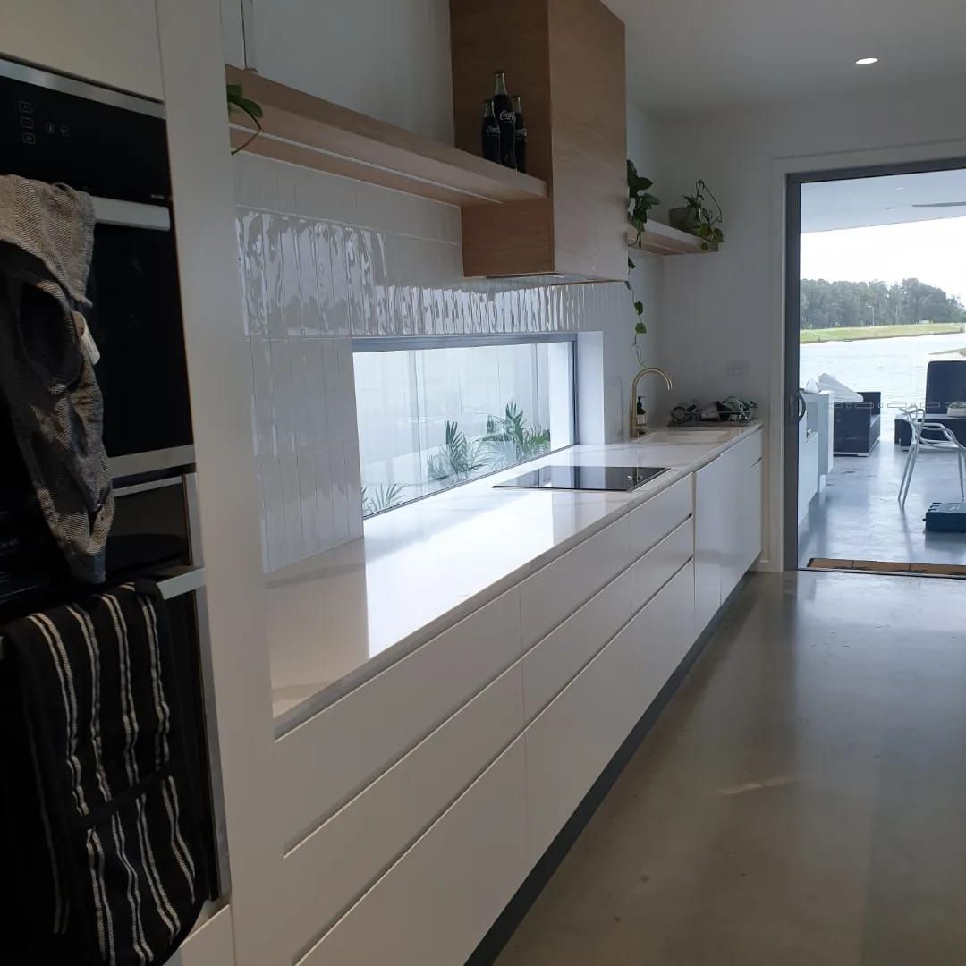A Kitchen With White Cabinets , a Sink , and a Window — Pacific Cabinets In Evans Head, NSW