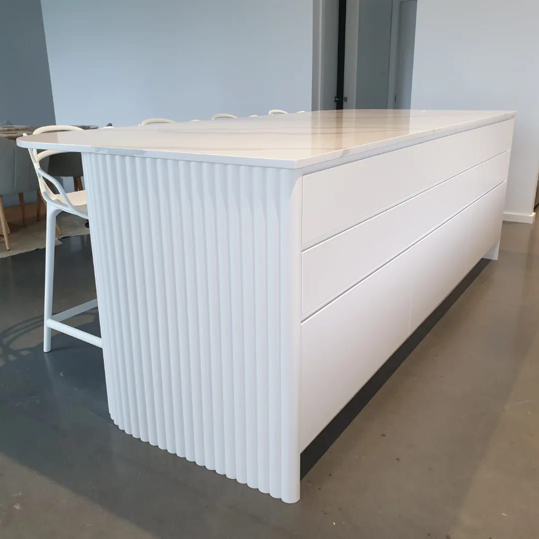 A Kitchen Island With a White Counter Top and Stools — Pacific Cabinets In Grafton, NSW