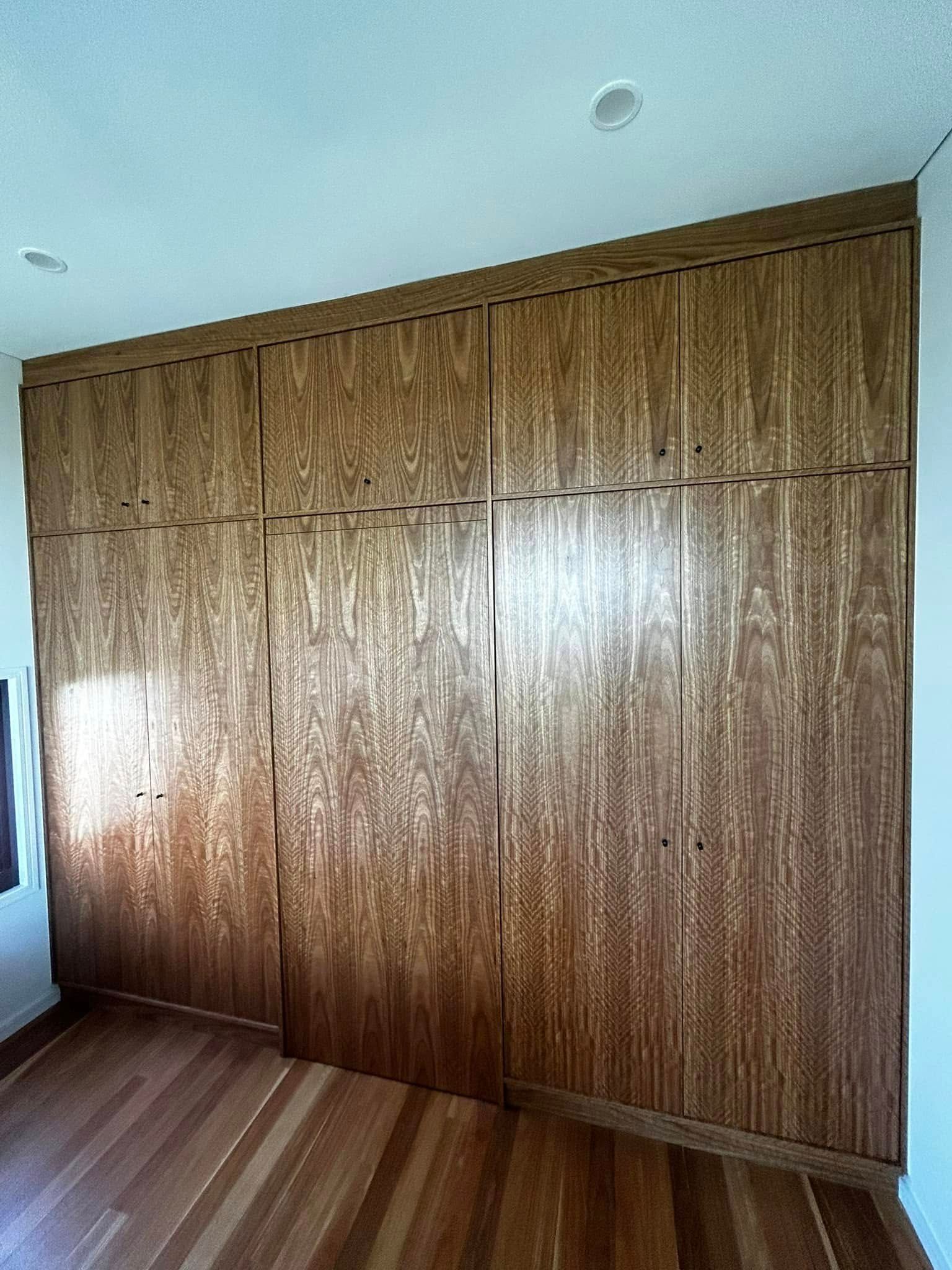 A Room With a Large Wooden Wall and Hardwood Floor — Pacific Cabinets In Yamba, NSW