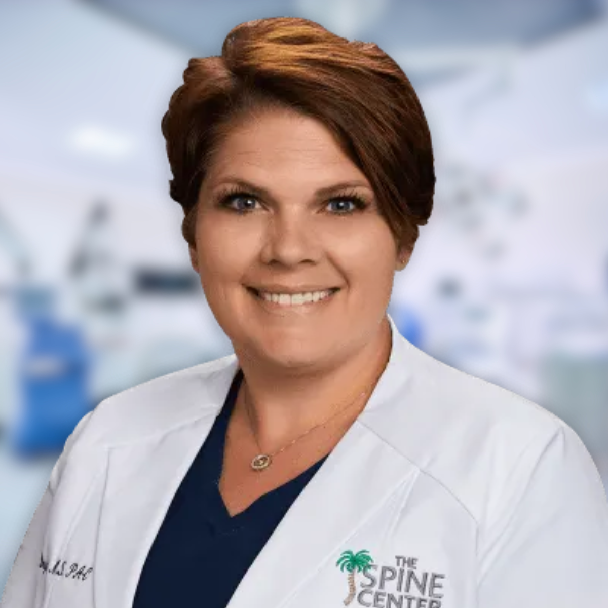 Woman, Dr. Rachel Ray, in white lab coat at The Spine Center. Smiling, brown hair.