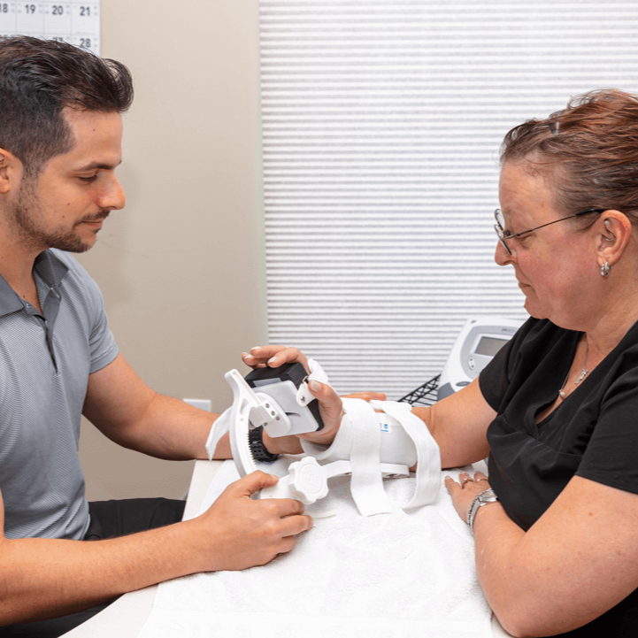 Man in suit smiling; blurred operating room background.