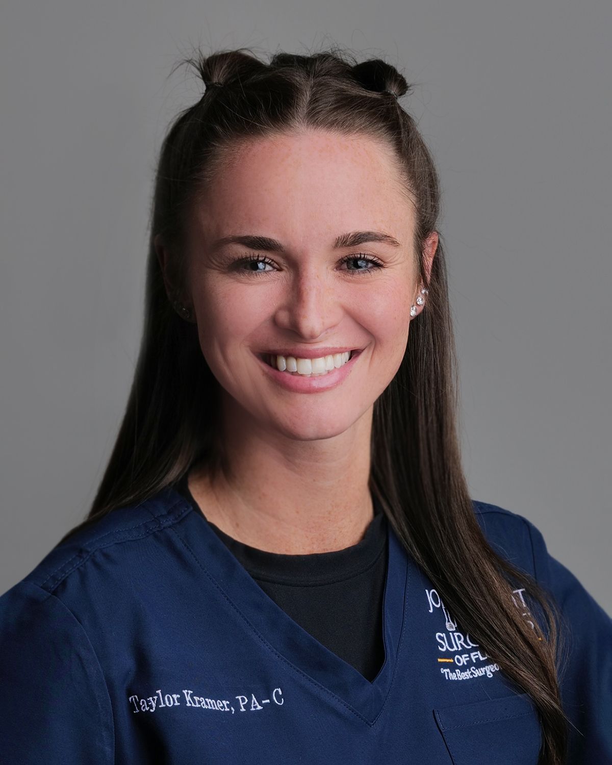 Woman in a white lab coat smiles, set in a medical office.