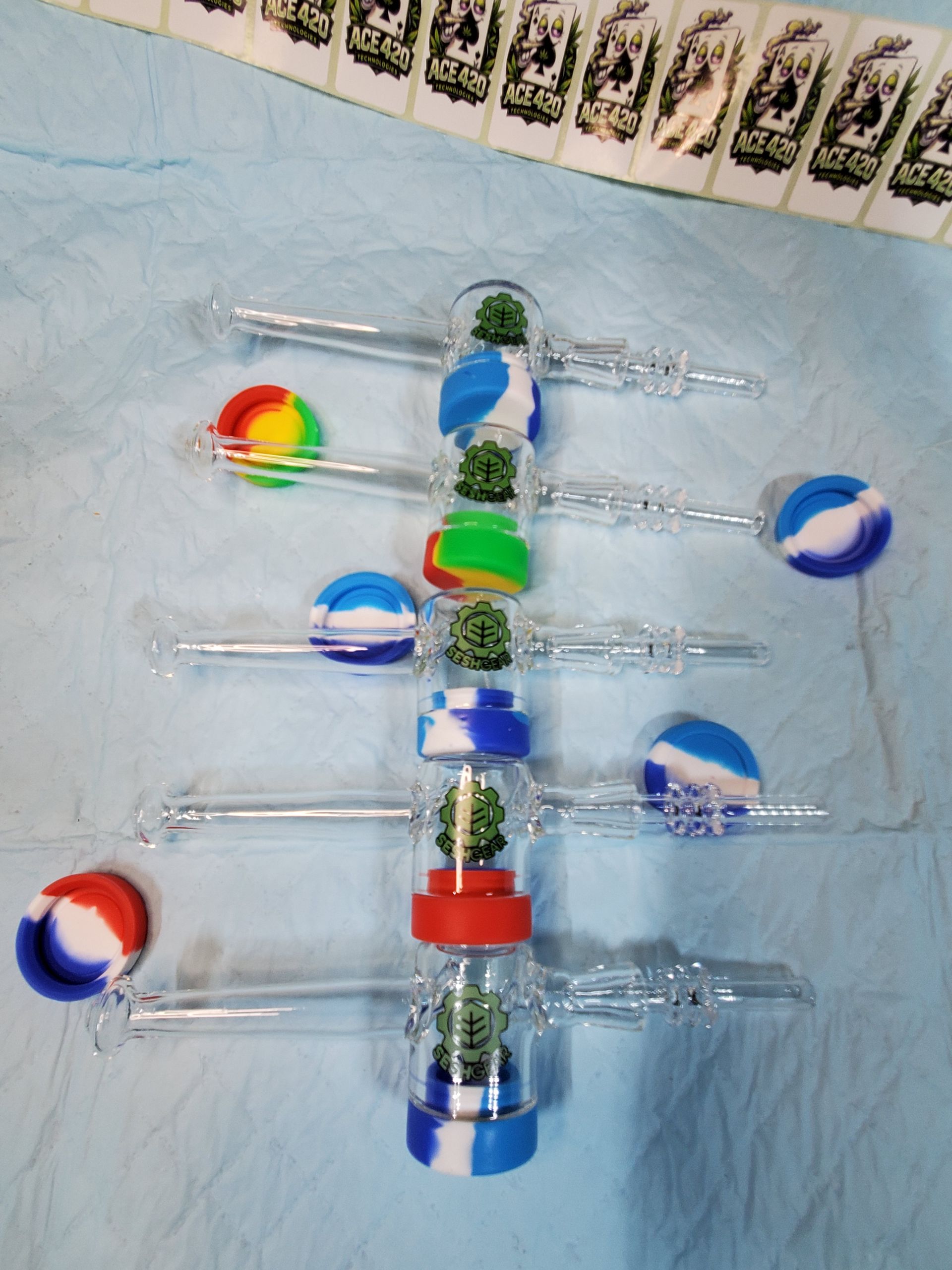 Colorful handmade wind turbine model with clear plastic blades and rainbow and blue circular accents on a blue surface