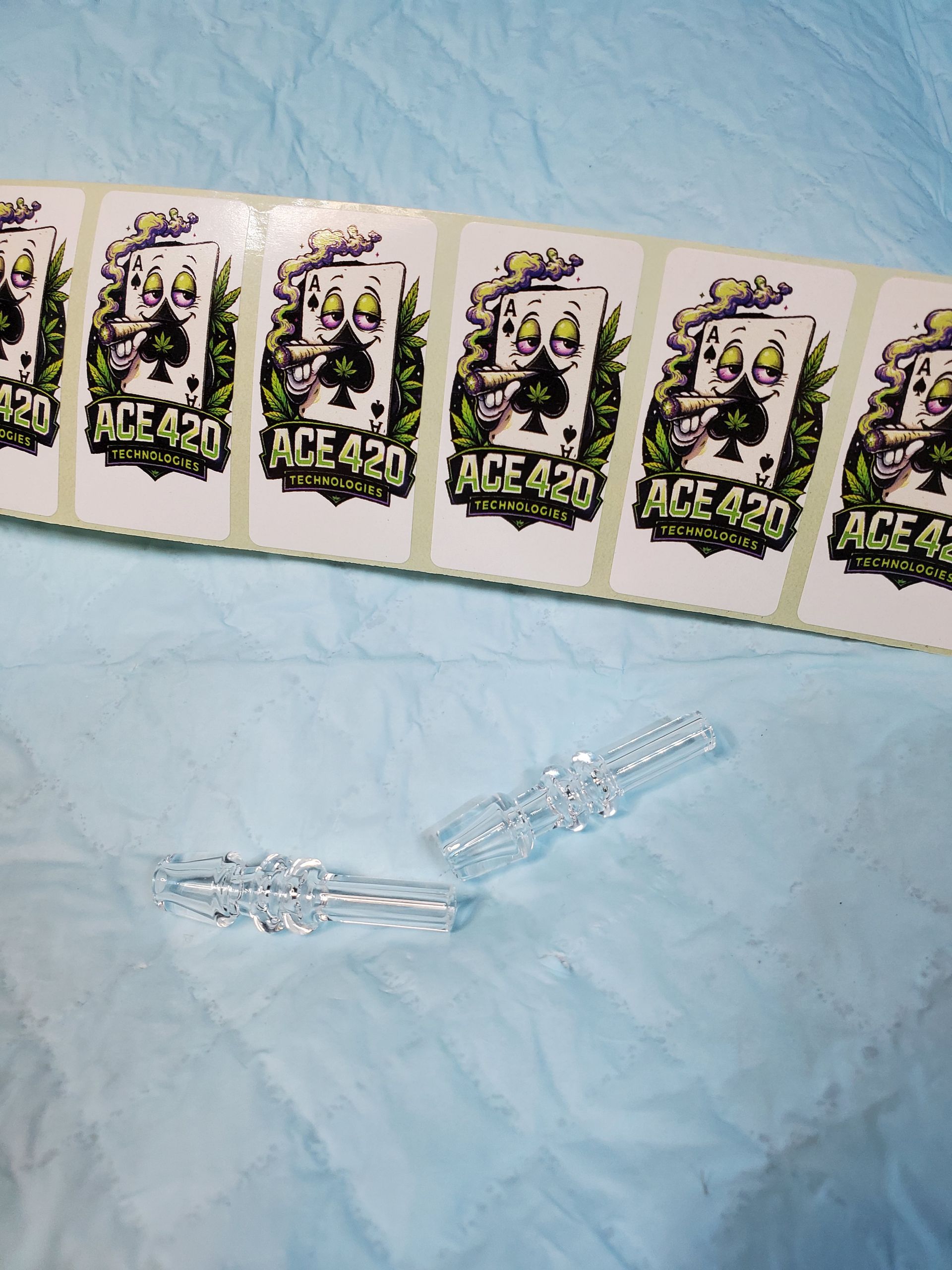 Row of ACE-themed cards on blue fabric with two clear plastic pieces below