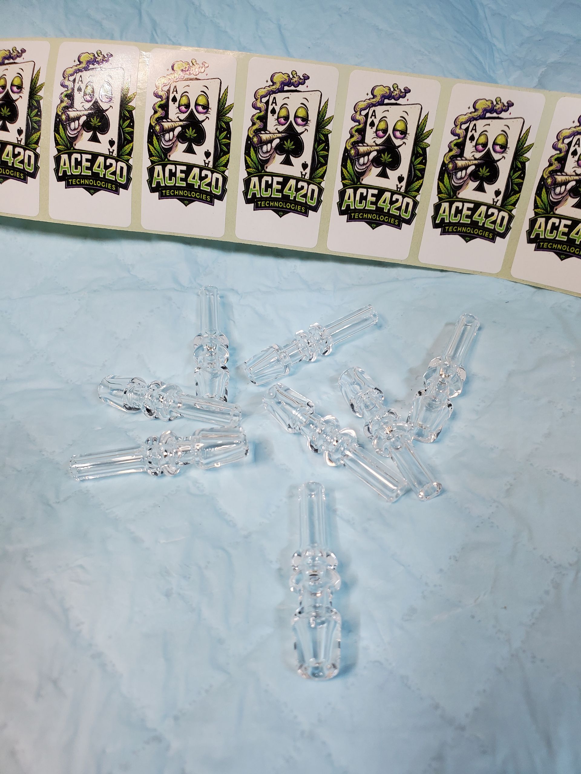 Clear ice crystals arranged on a light blue surface beneath a row of playing cards.