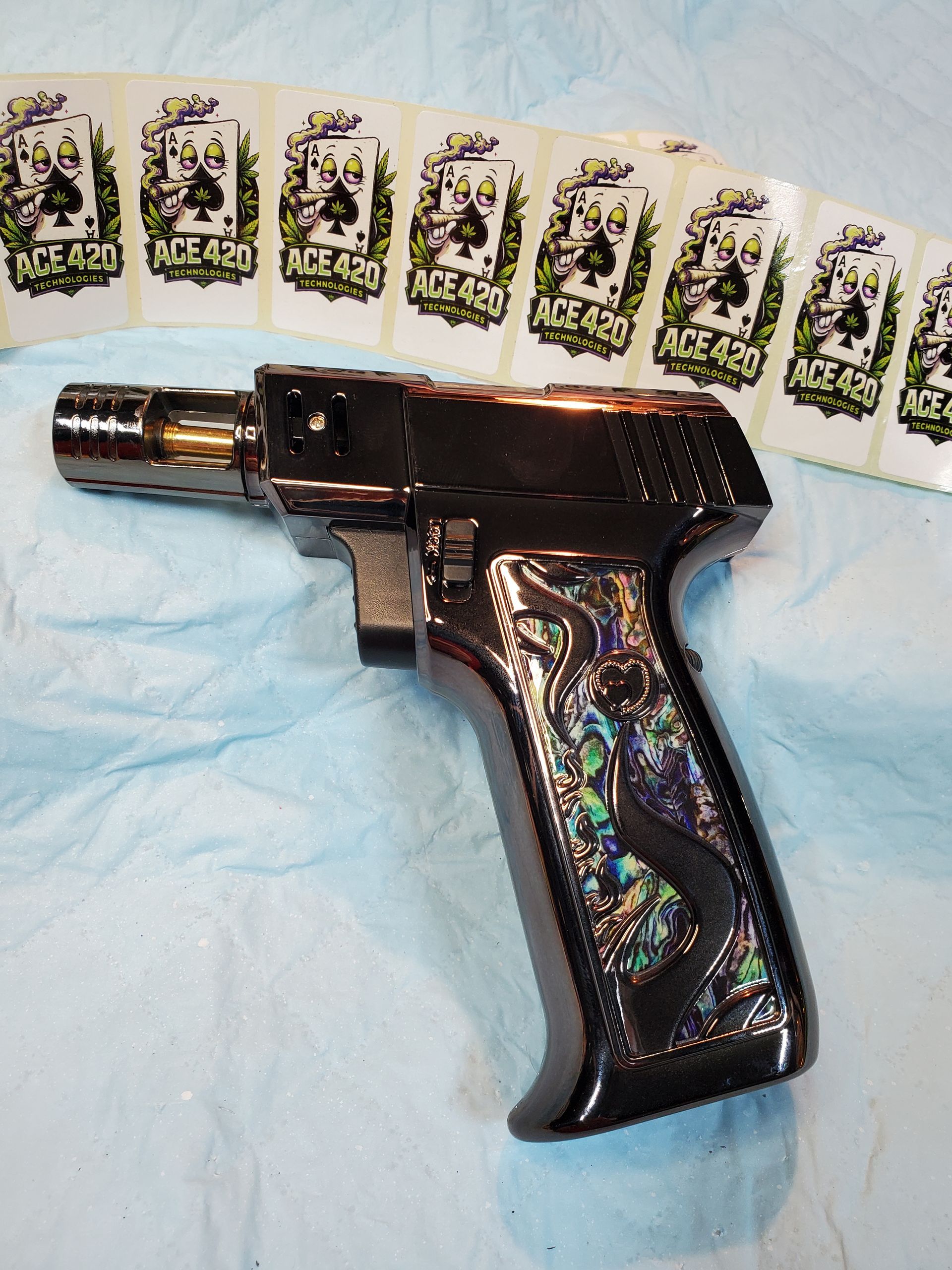 Black toy gun on a light blue cloth with a row of playing cards above it
