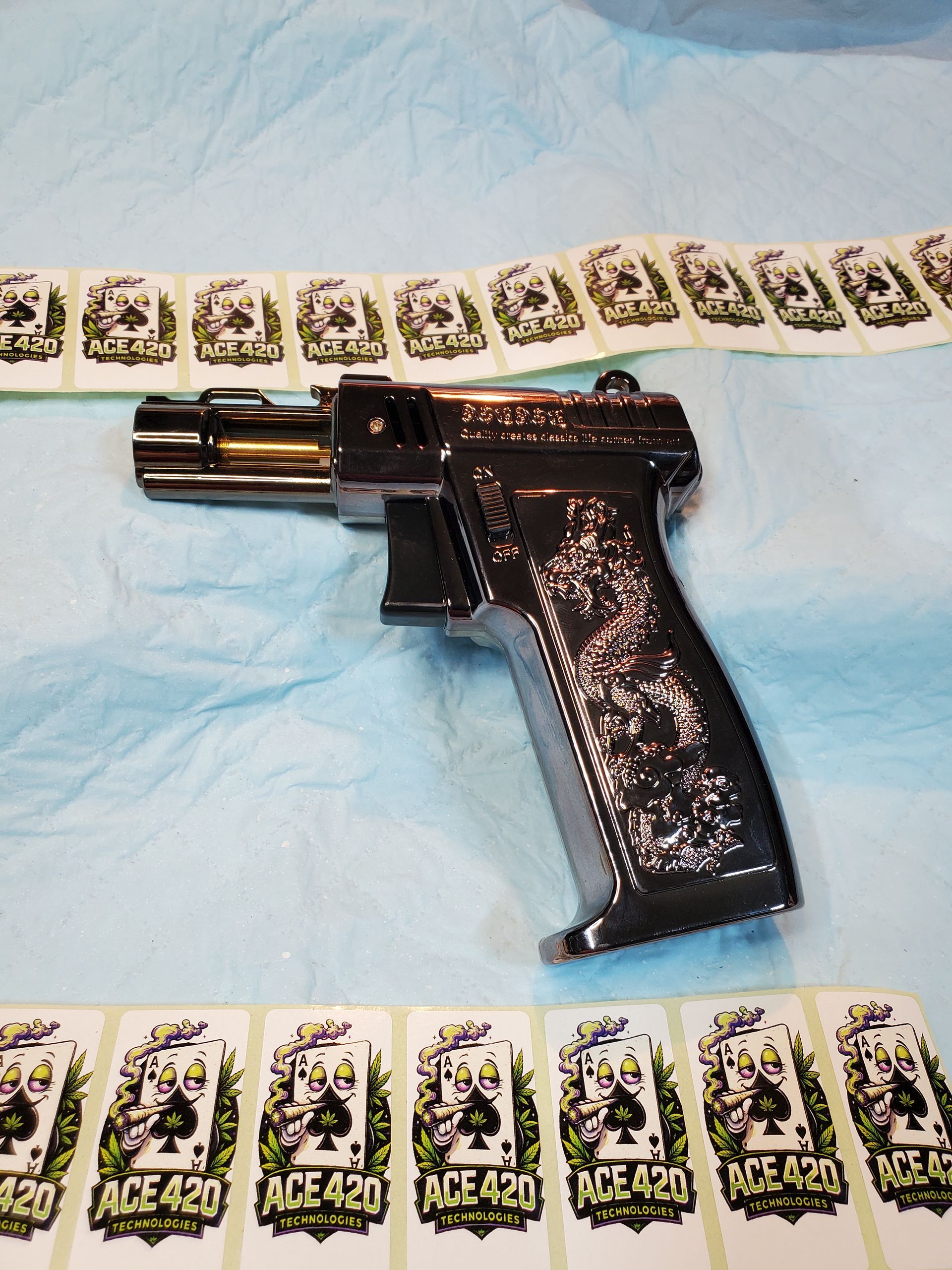 Black handgun on a blue cloth, surrounded by rows of small rectangular cards or packets.