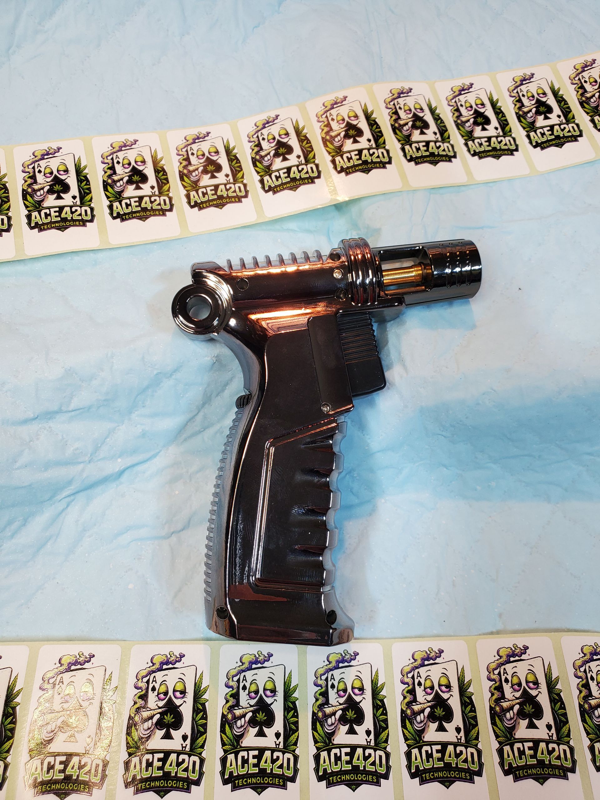 Black sci-fi blaster toy on a light blue surface, bordered by playing cards.