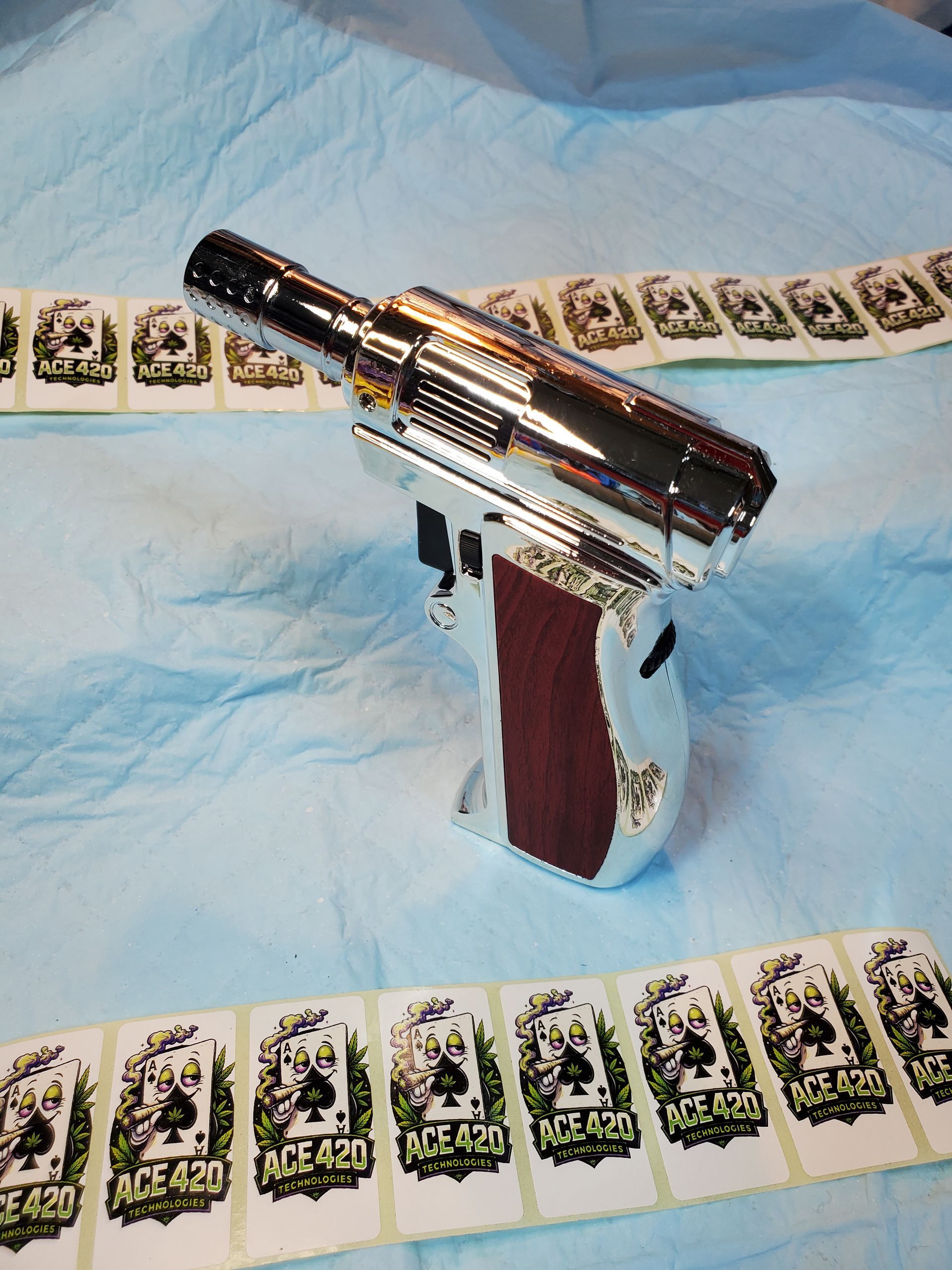 Chrome toy gun on a white cloth, surrounded by playing cards.