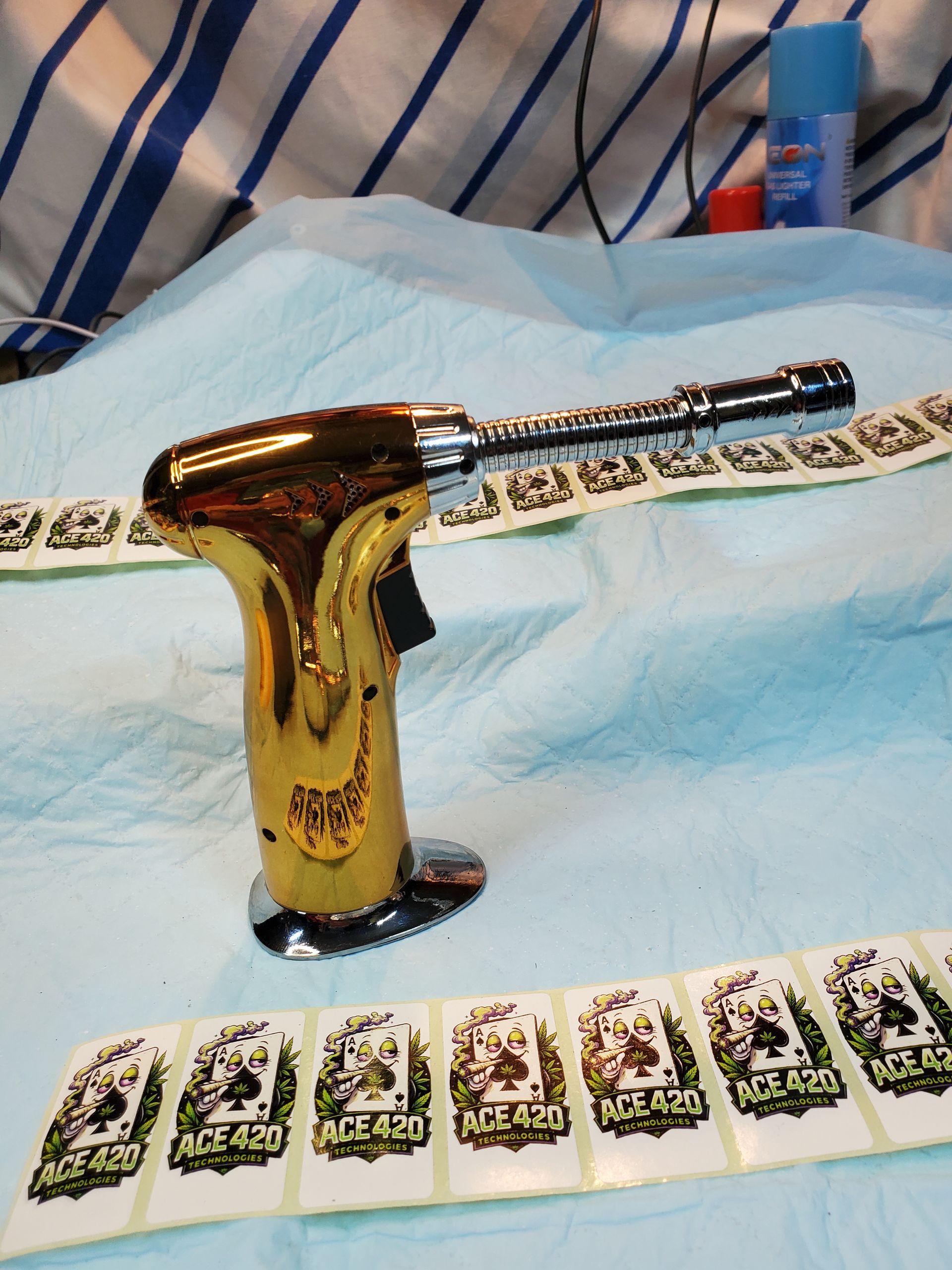 Gold-colored object on a bed of banknotes, with a blue surgical mask and striped fabric in the background
