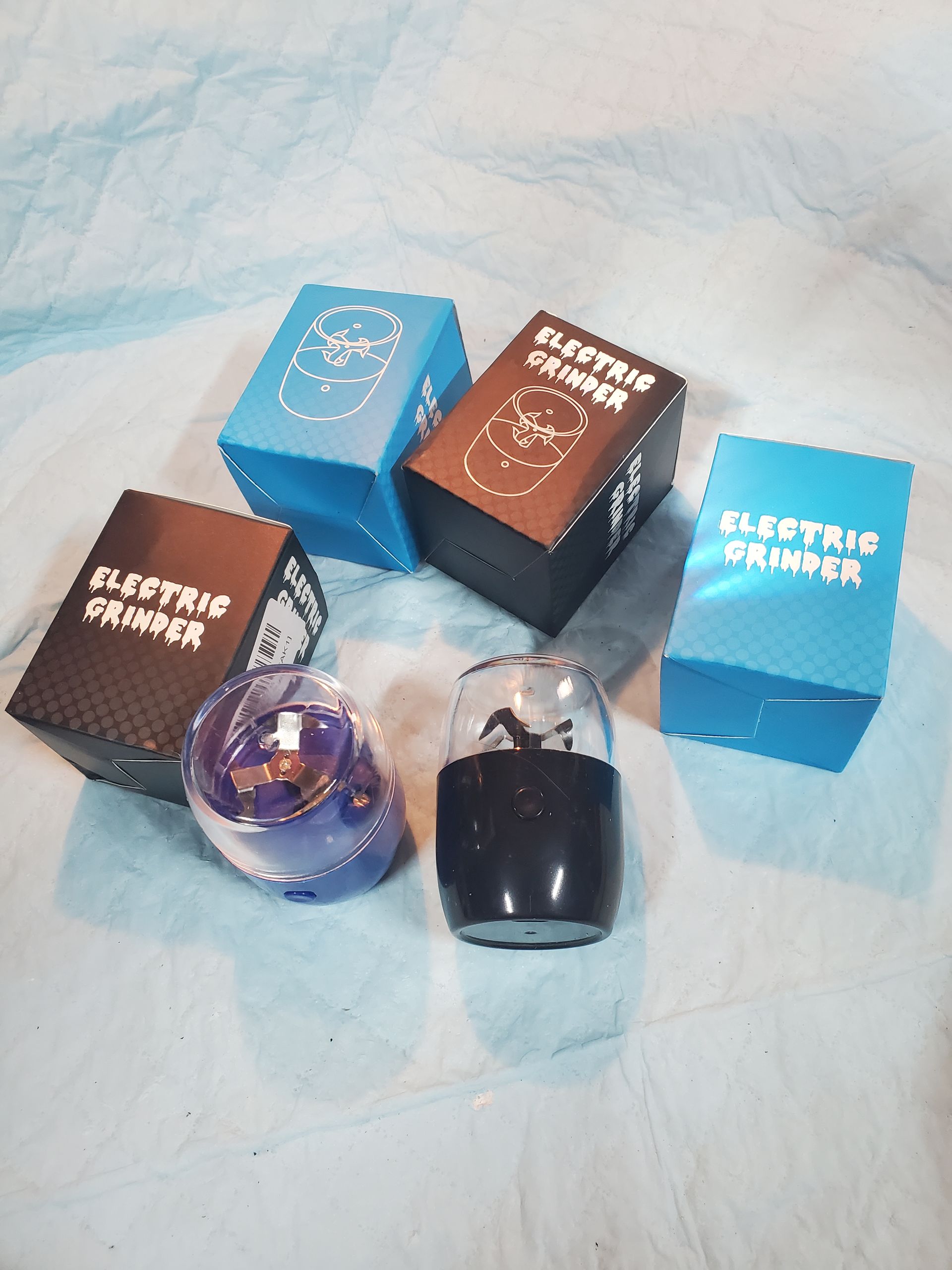 Four Electra-branded vape boxes with two vape devices on a light blue fabric background