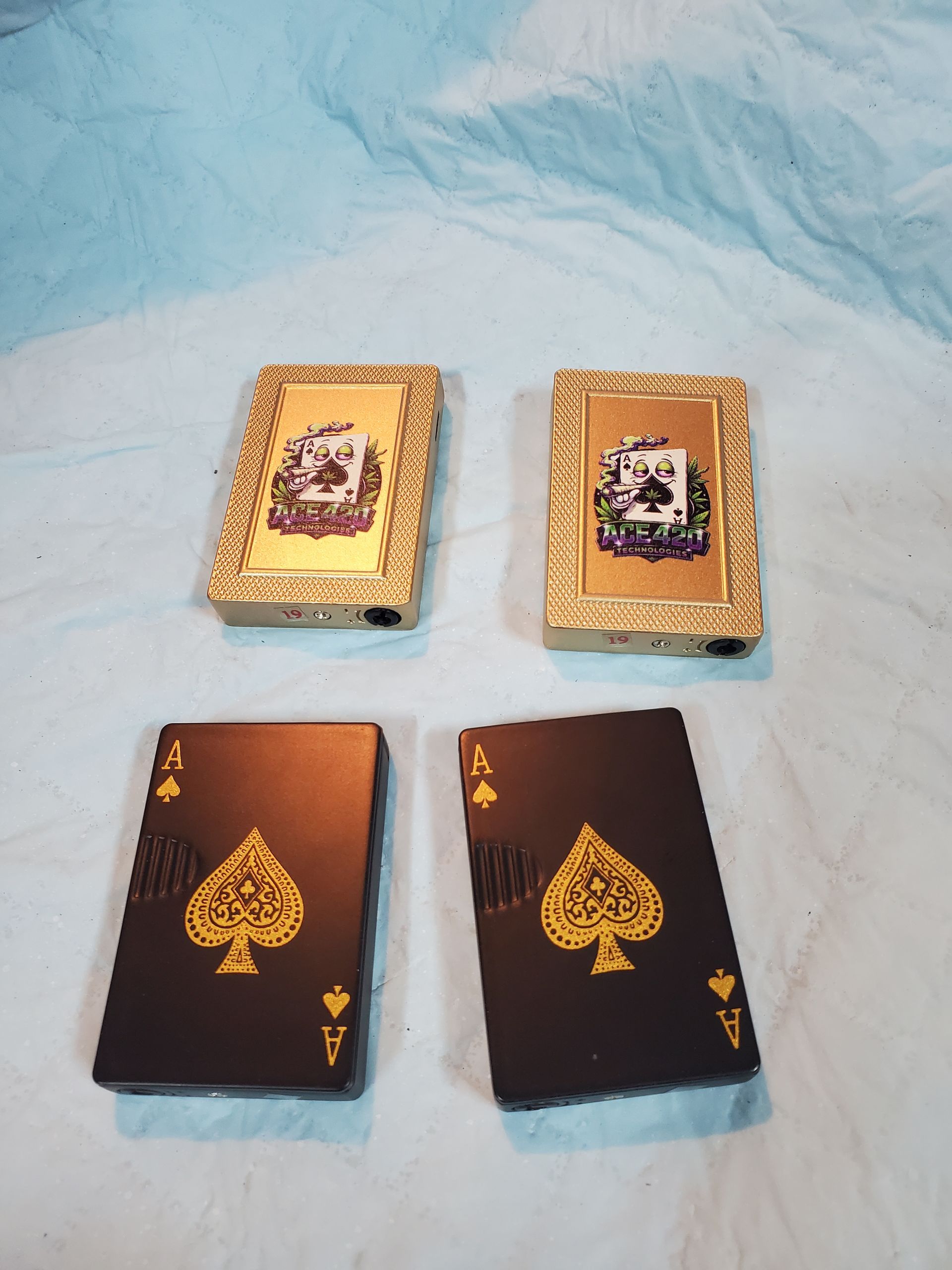 Four small card decks on a light blue textured surface, two brown and two gold-patterned.