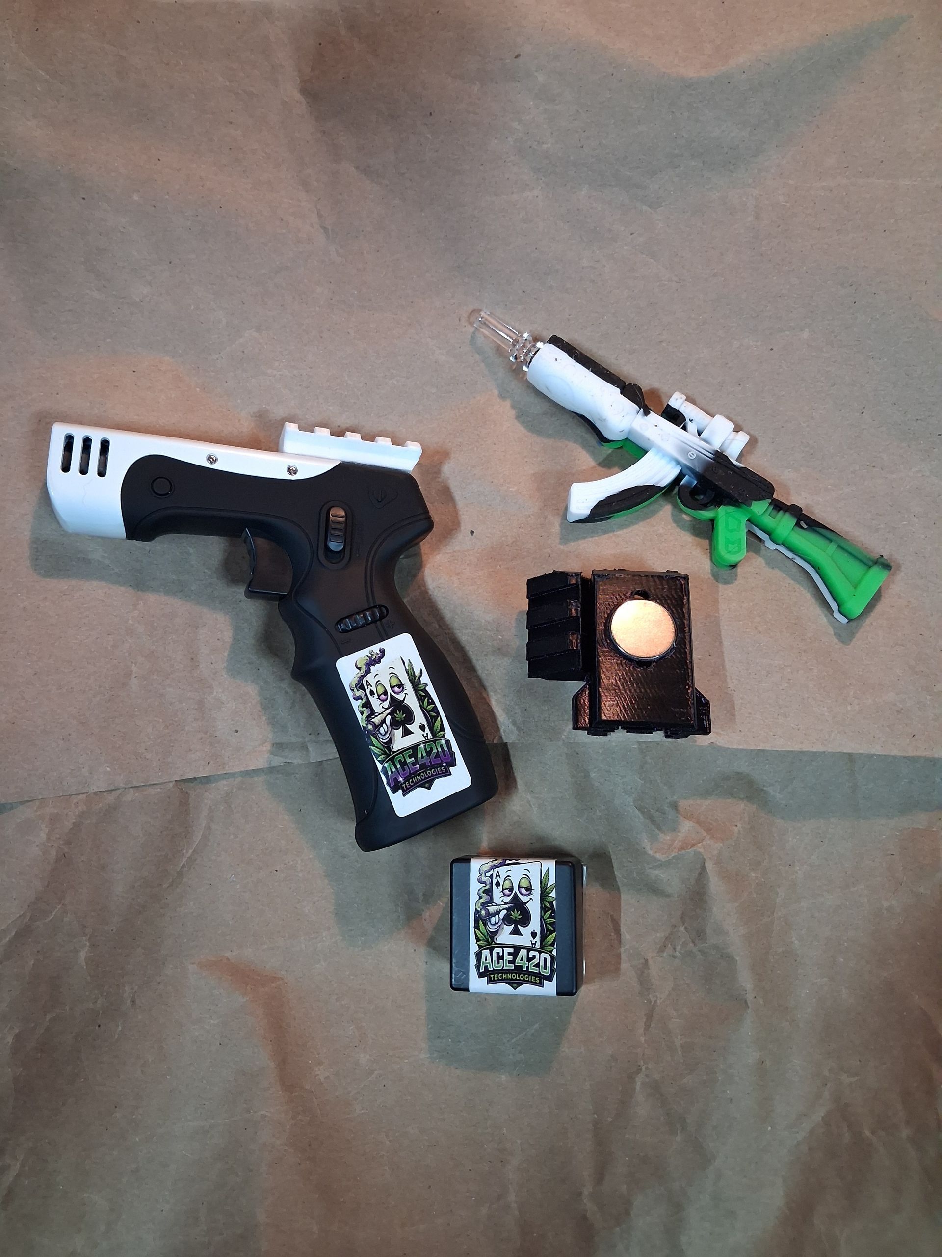 Three toy guns and two small toy accessories on a tan fabric surface