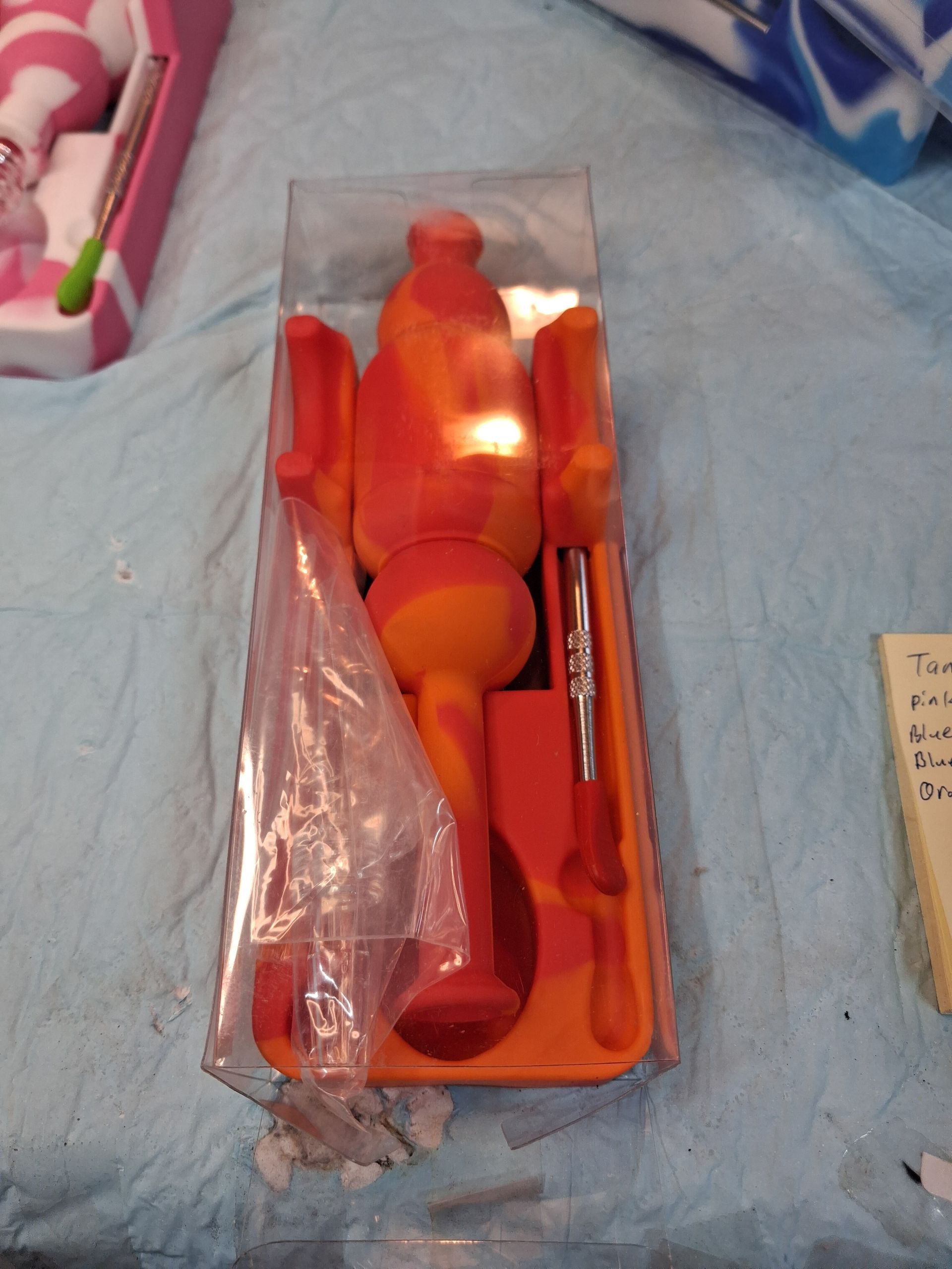 Orange toy utensils in a plastic tray on a bedspread