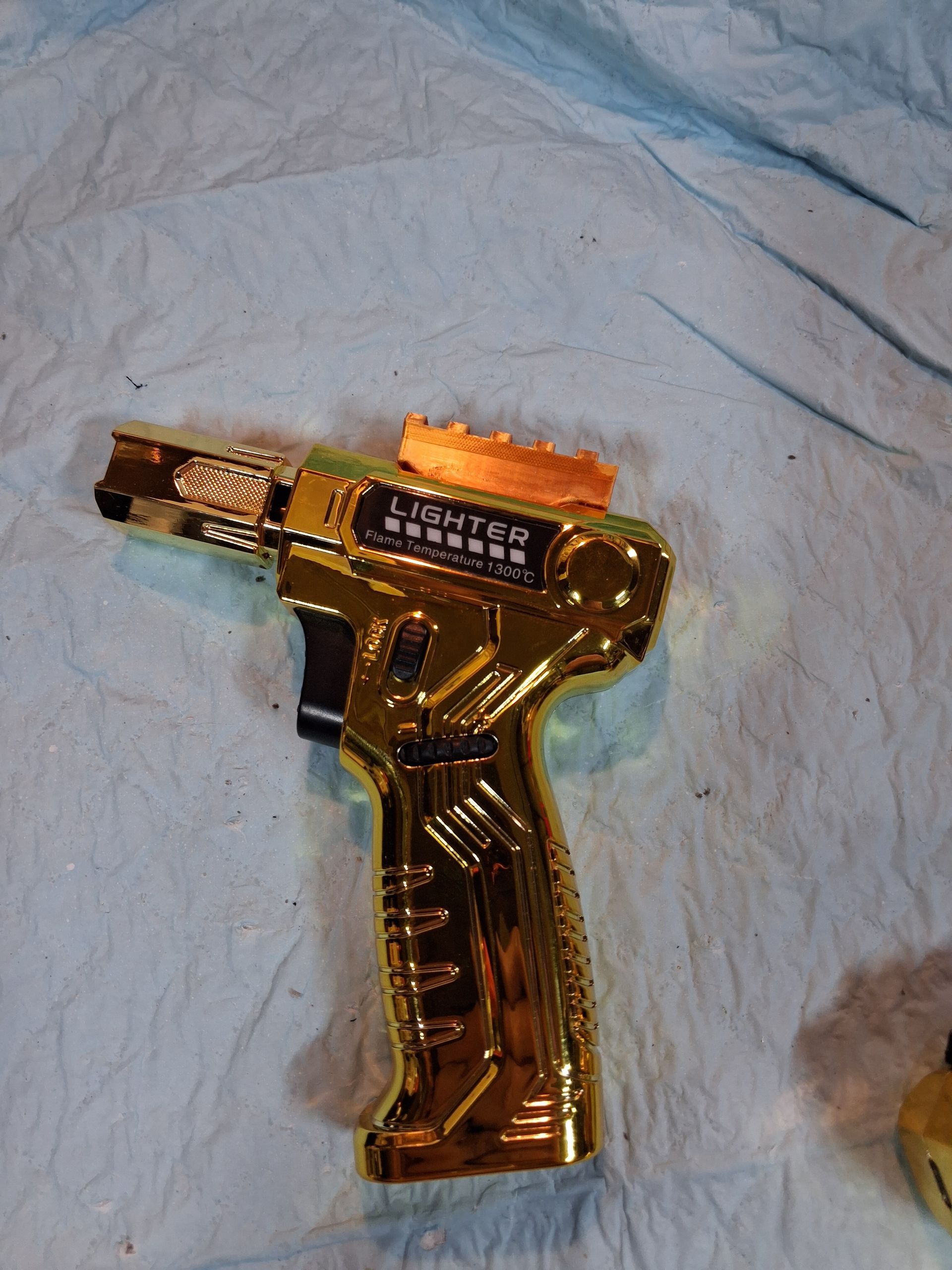 Gold toy gun on a blue cloth background
