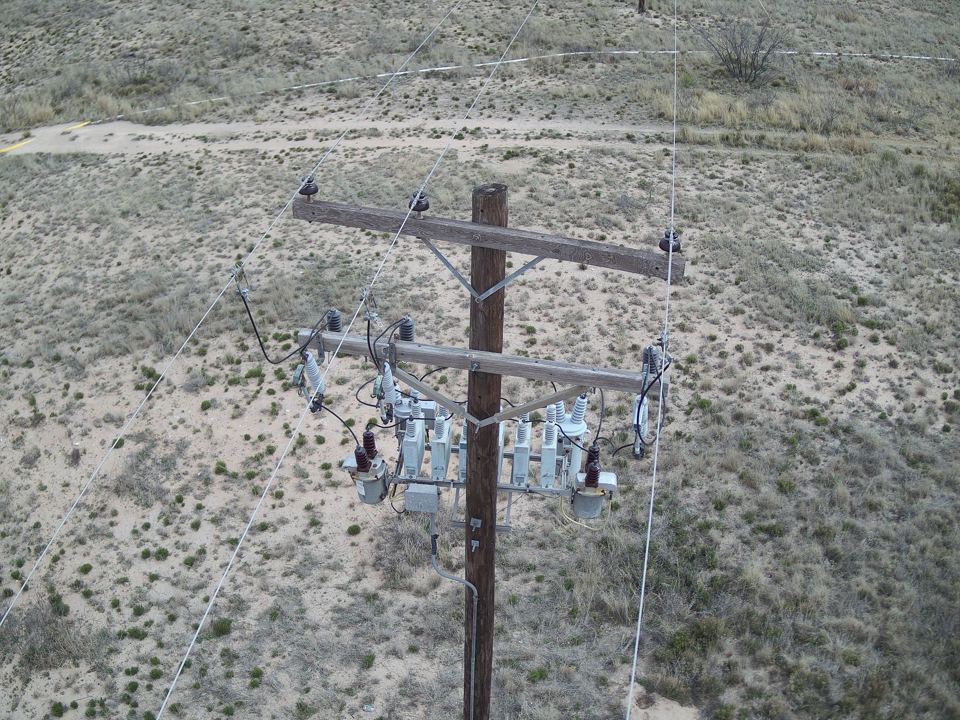 An aerial view of a power line in the middle of a desert.