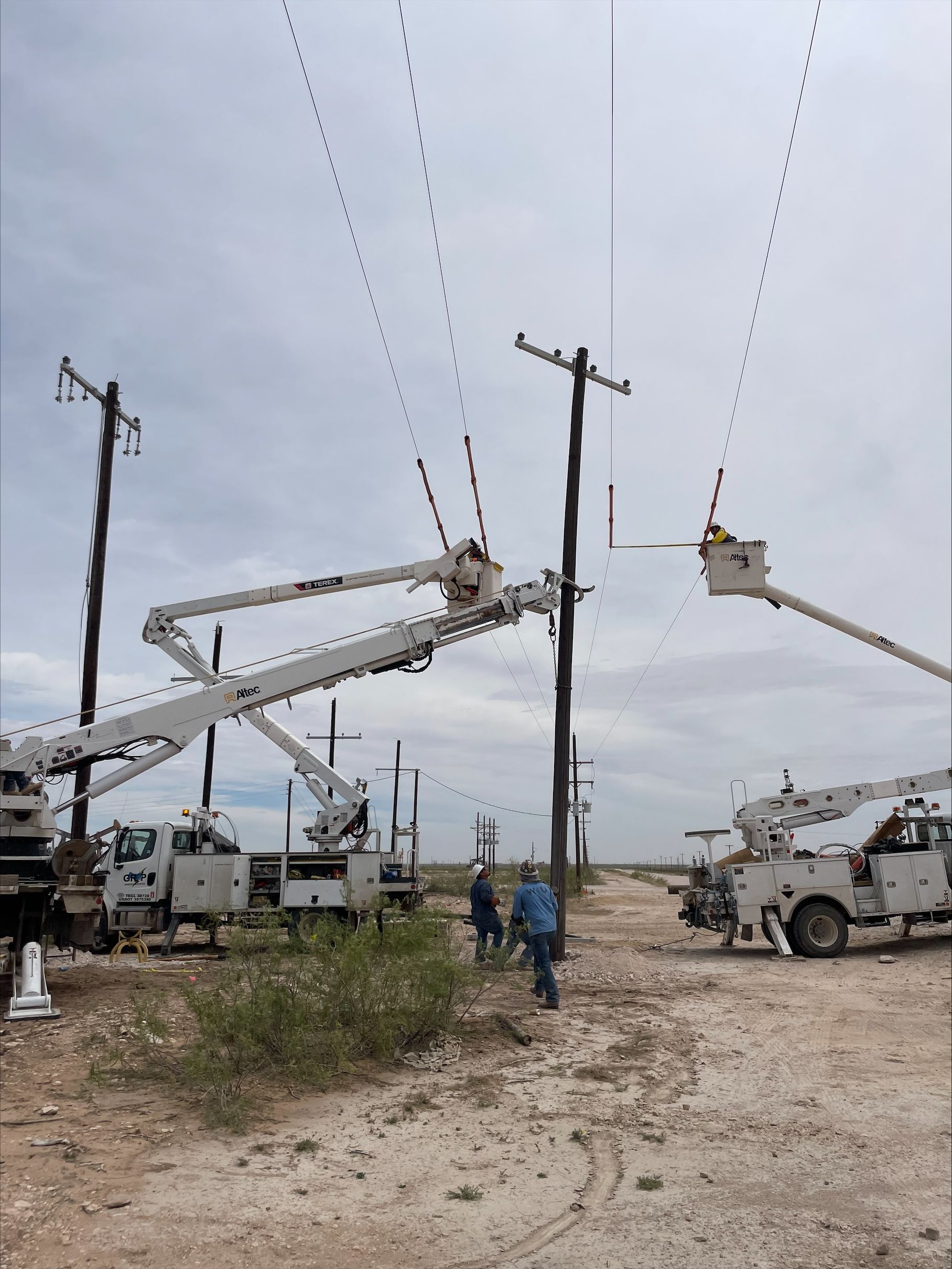 A group of utility trucks are working on power lines