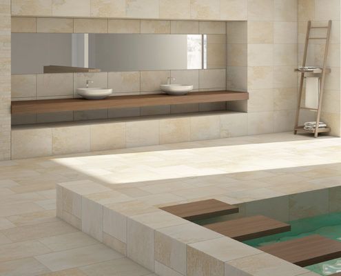 Ein Badezimmer mit Fliesen mit zwei Waschbecken und einem großen Spiegel