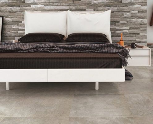 Ein Schlafzimmer mit einem großen Bett und einer Steinfliesenwand