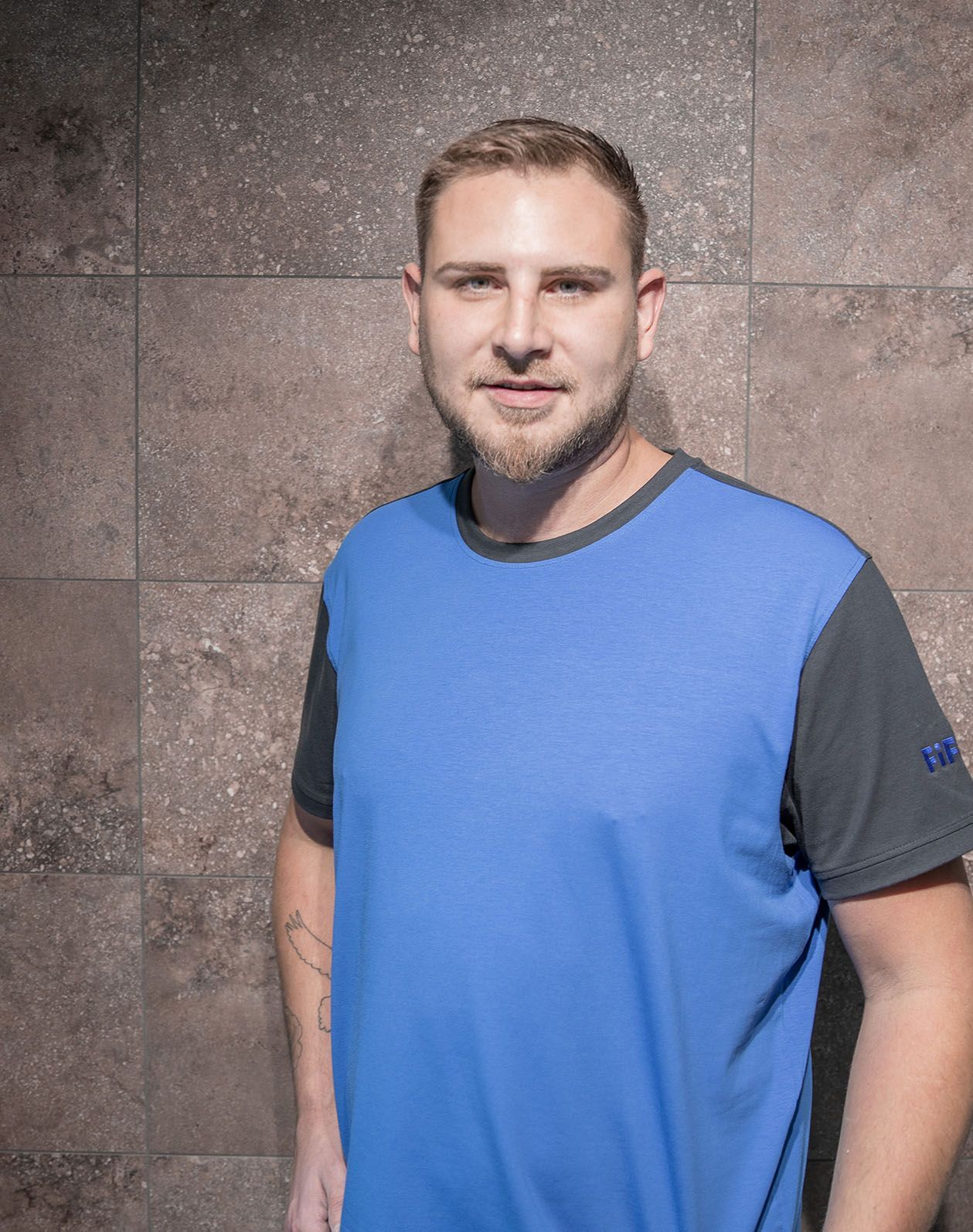 Das Portrait eines Mitarbeiters Marcel Kirchmair mit einem blauen T-Shirt