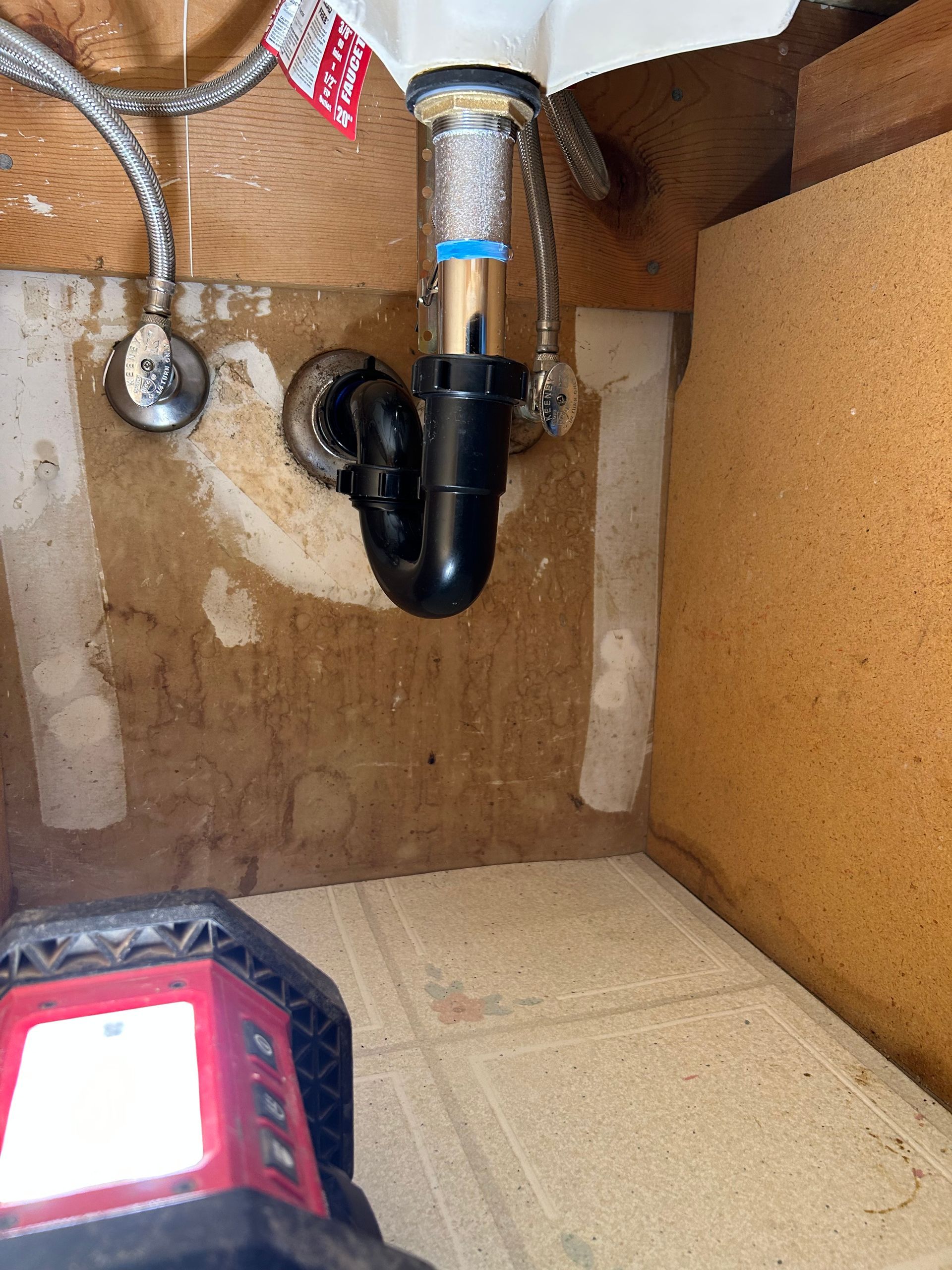 A bathroom sink with a black pipe underneath it