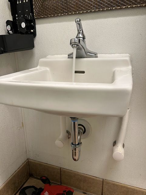 A bathroom sink with water running from the faucet