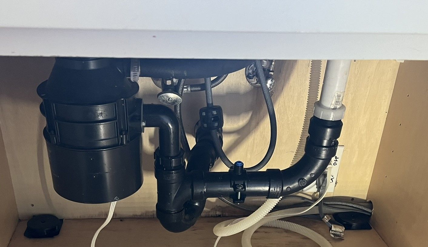 A sink with a garbage disposal underneath it